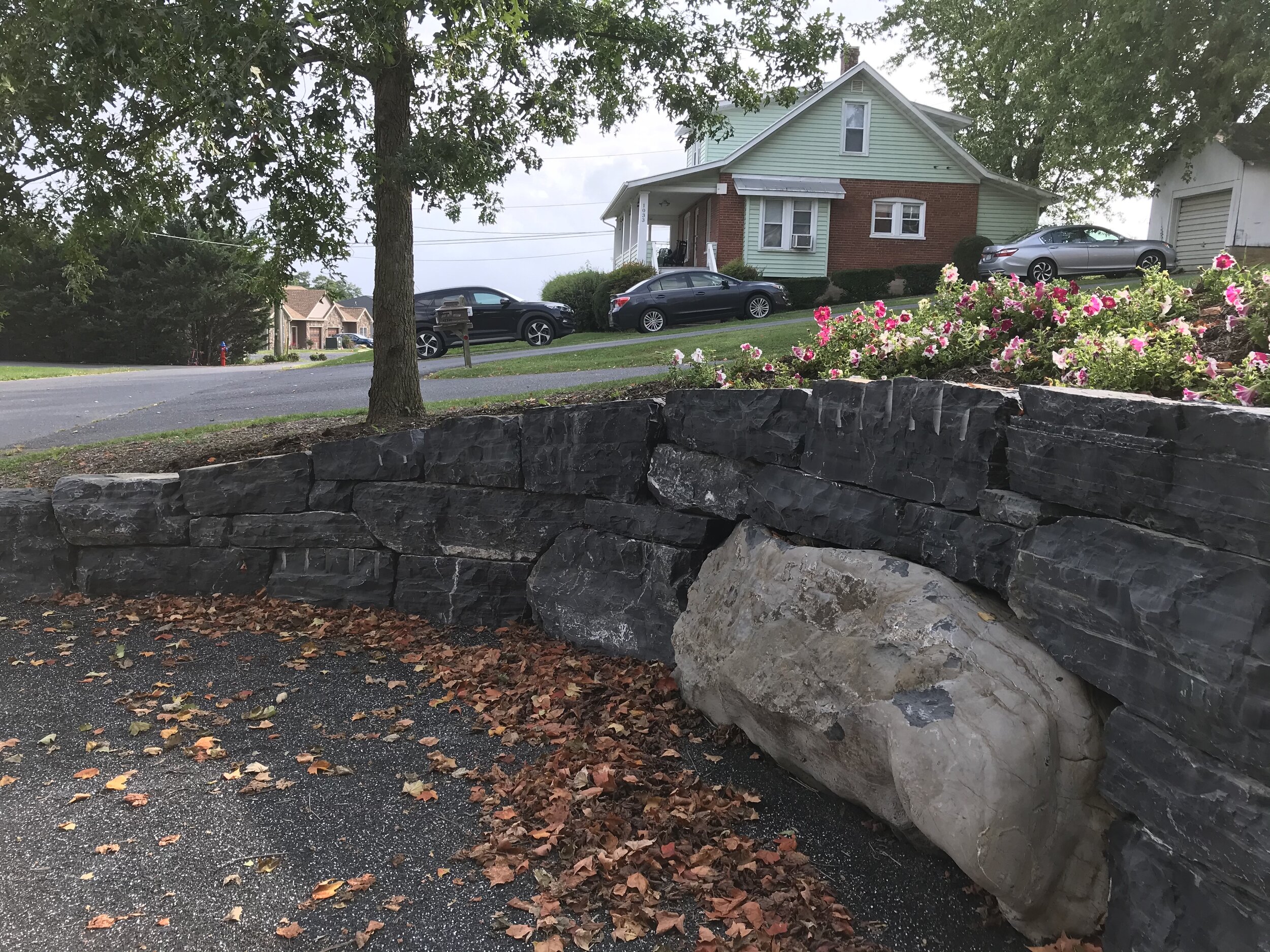 Gravel parking with stone retaining wall and boulder.jpg