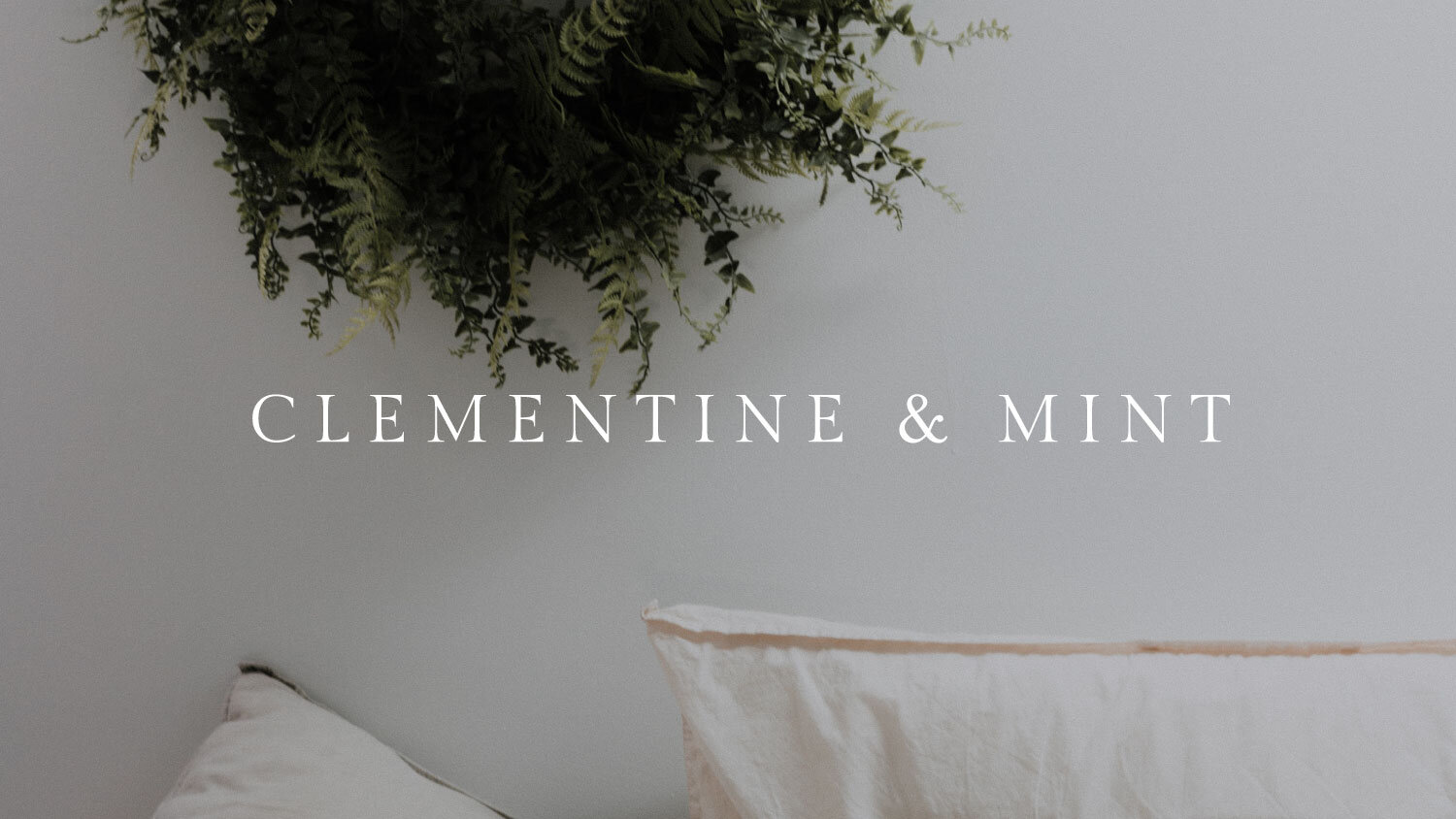 Clementine and Mint's main logo on a photograph of a natural real wreath