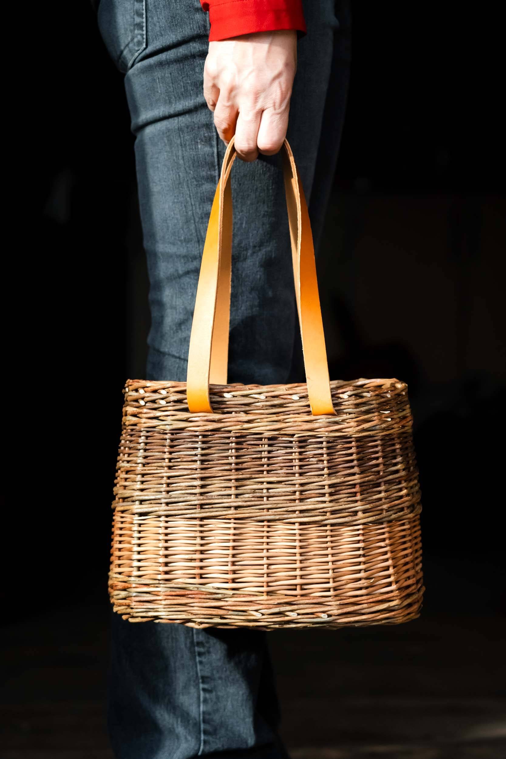 person holding willow bag