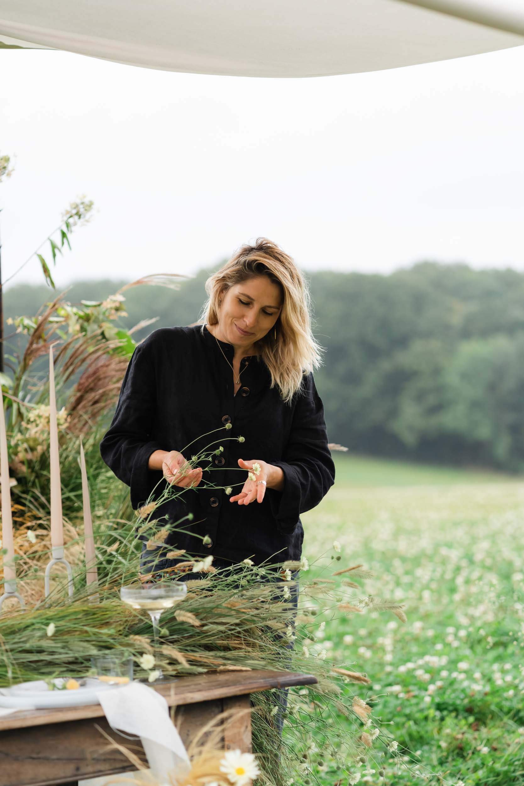 florist at a table in meadow set up for wedding