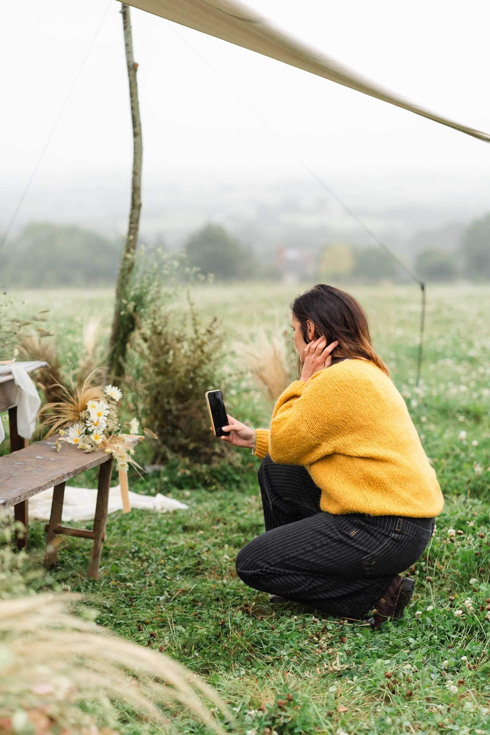 florist at a table in meadow set up for wedding