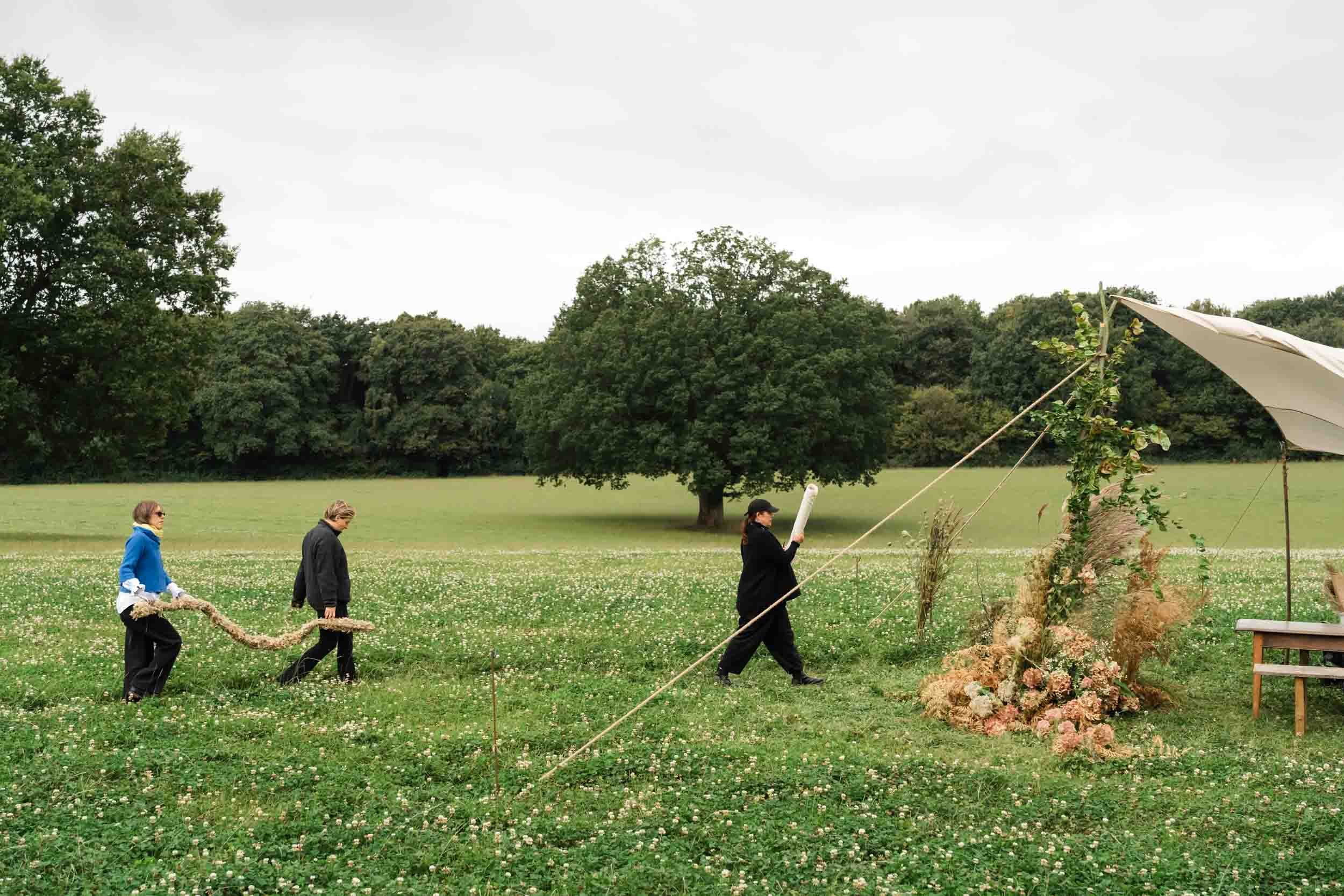 florists setting up tablescape in meadow