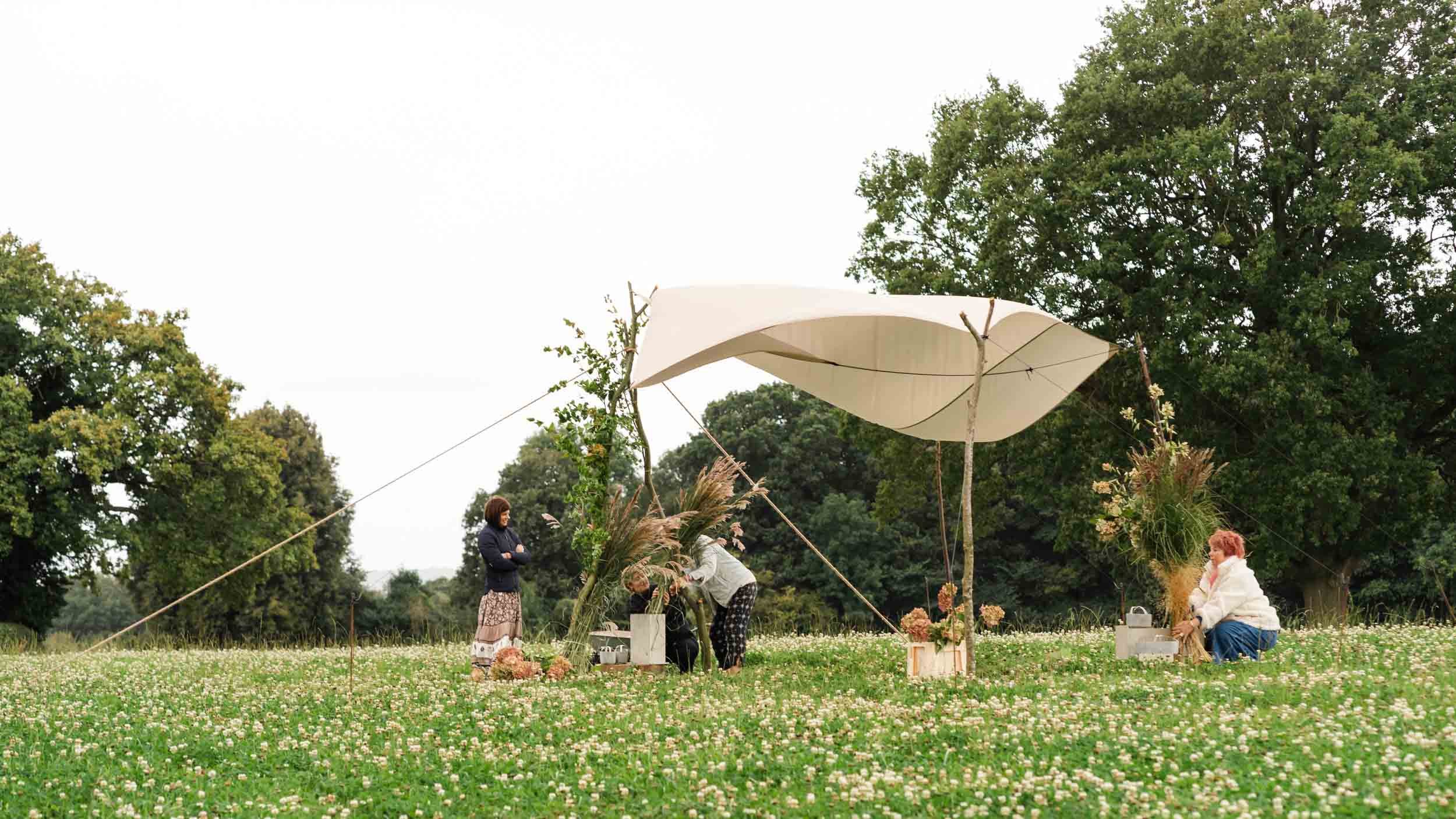 florists decorating tent in field
