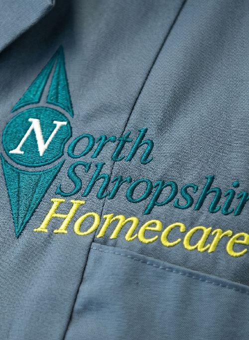 Embroidery of North Shropshire Homecare logo on a blue uniform.