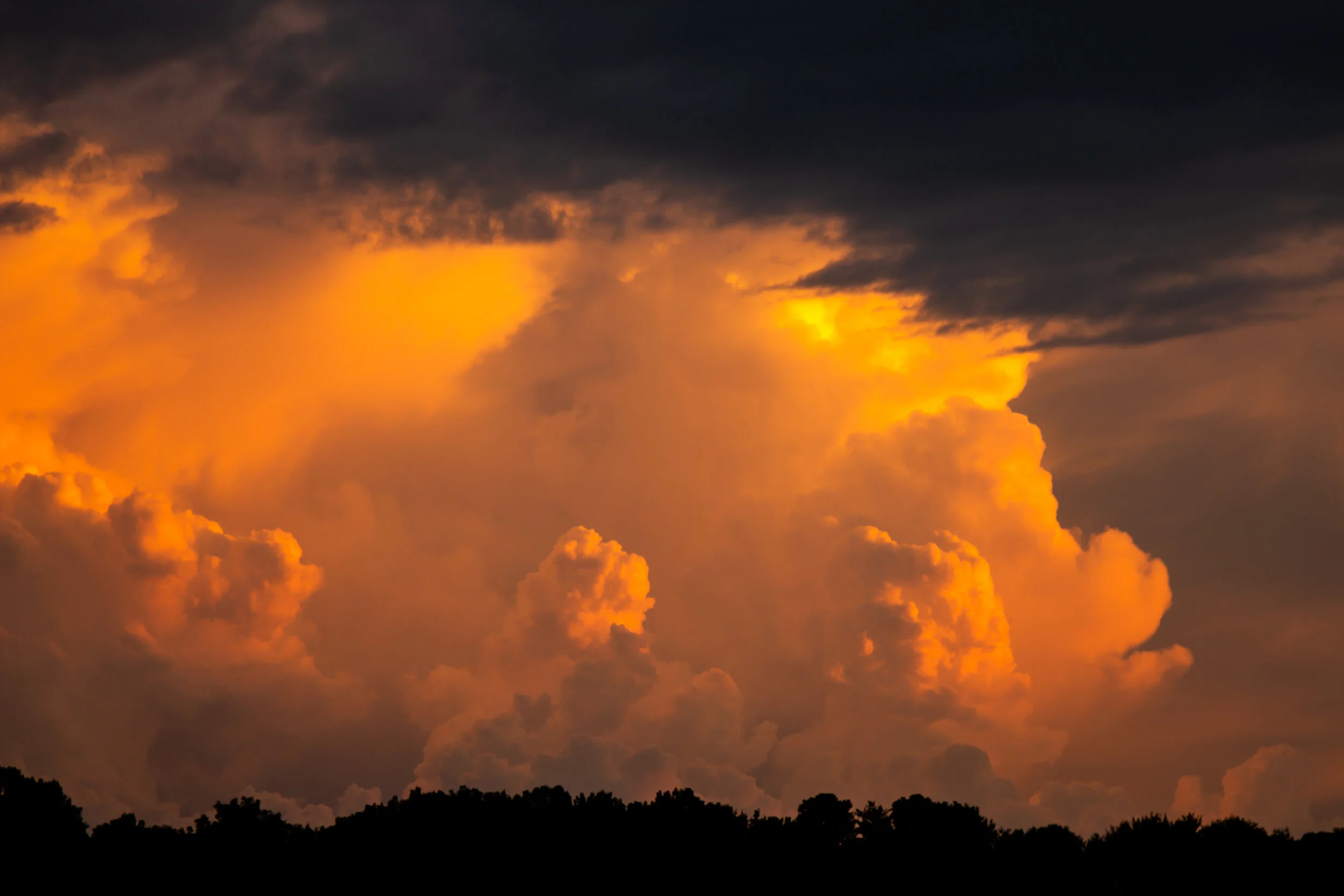 Aerial of a cloudy sunset, bright sunburst orange