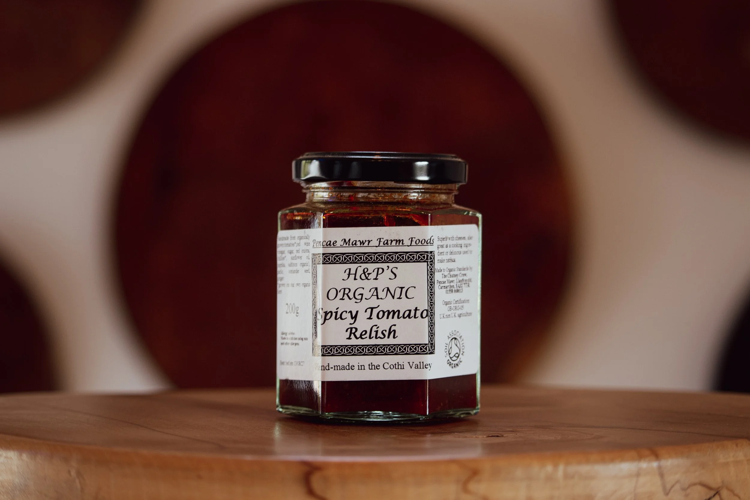 Spicy Tomato Relish on wooden table in farm shop