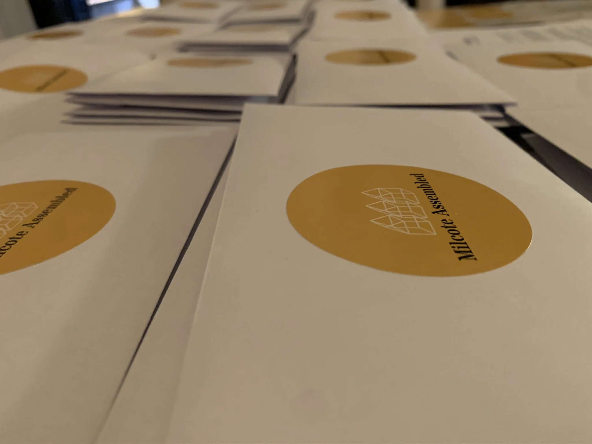 Multiple white cards with a yellow circle logo and black text, stacked and spread on a flat surface.