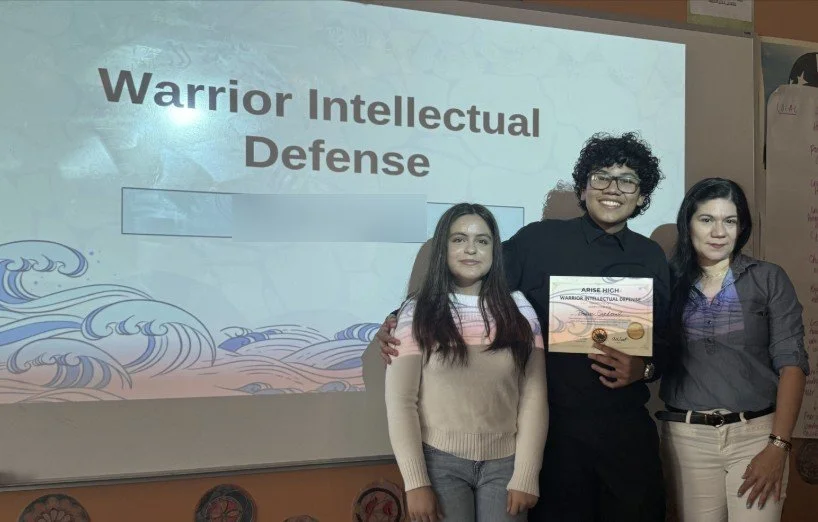 An ARISE senior holding his Warrior Intellectual Defense certificate