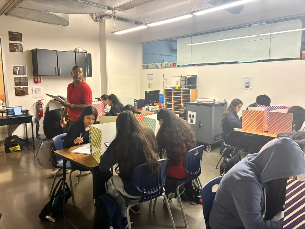 An ARISE teacher checking in with students as they work in class