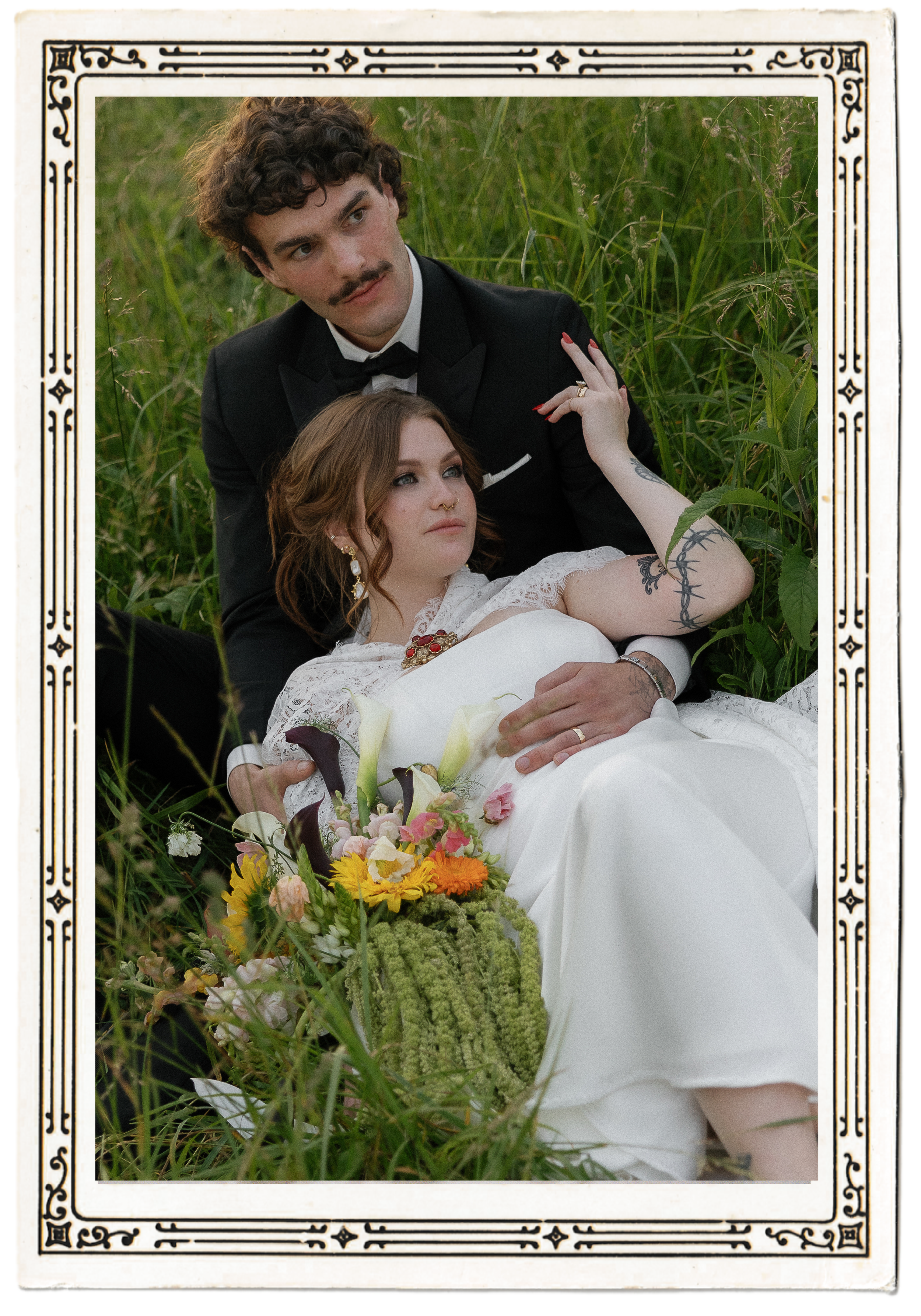 Dreamy wedding portrait of a bride and groom lying in a grassy field