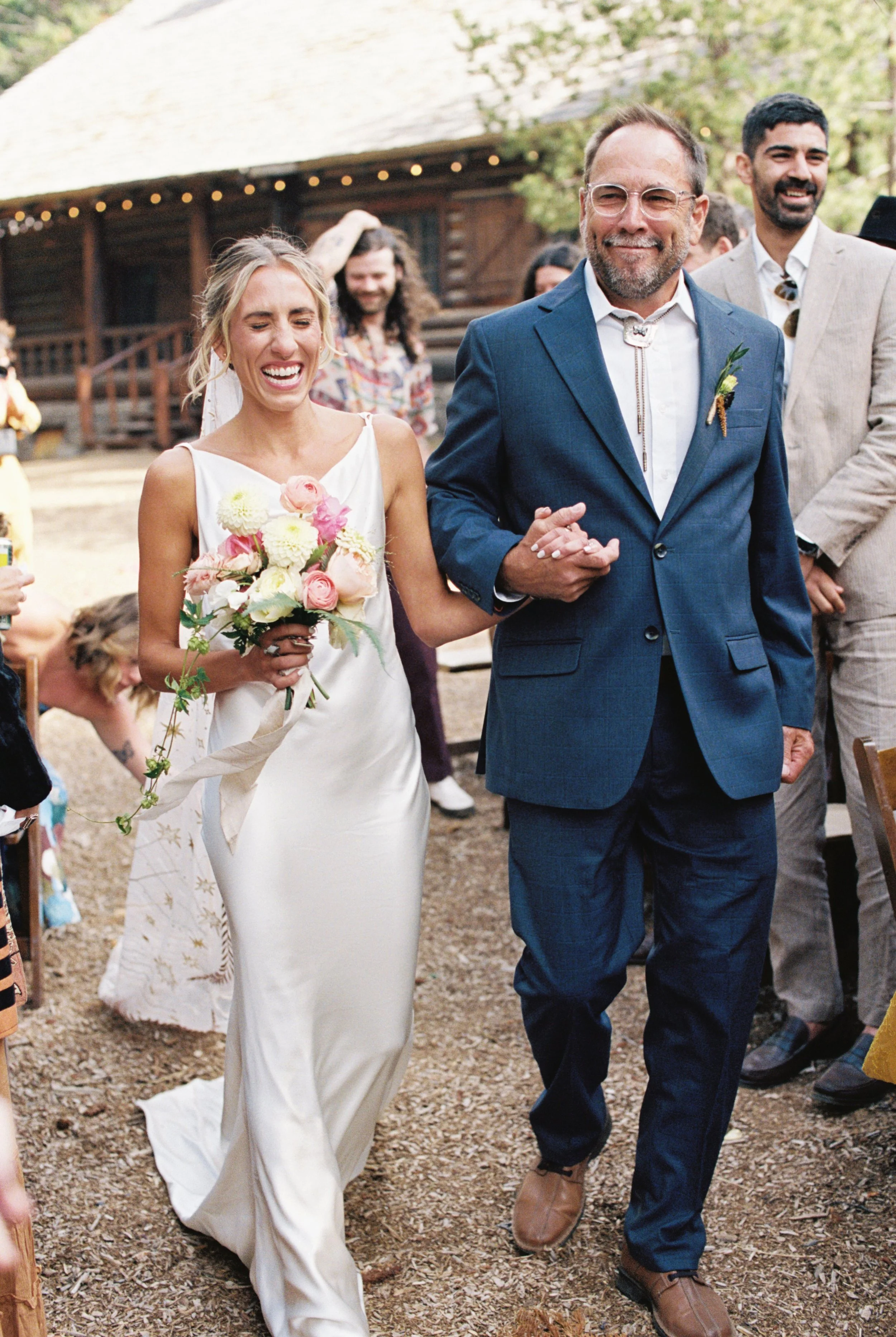 Dad walking his daughter down the isle, full of smiles and emotions