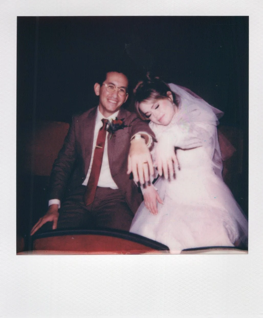Polaroid of a bride and groom showing off their wedding rings