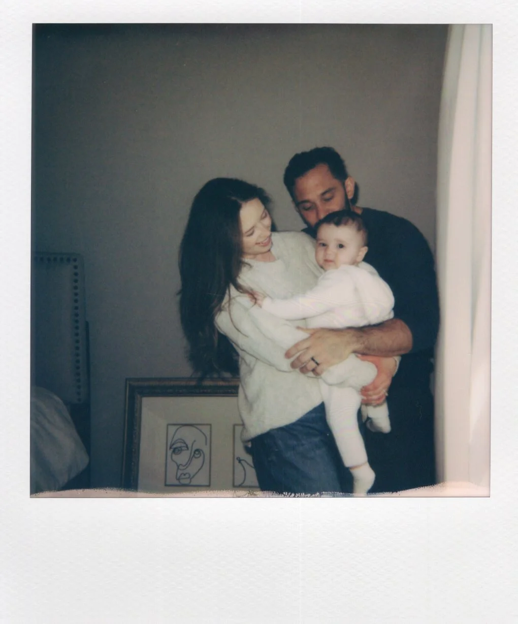 Polaroid of a mom and dad holding their young child