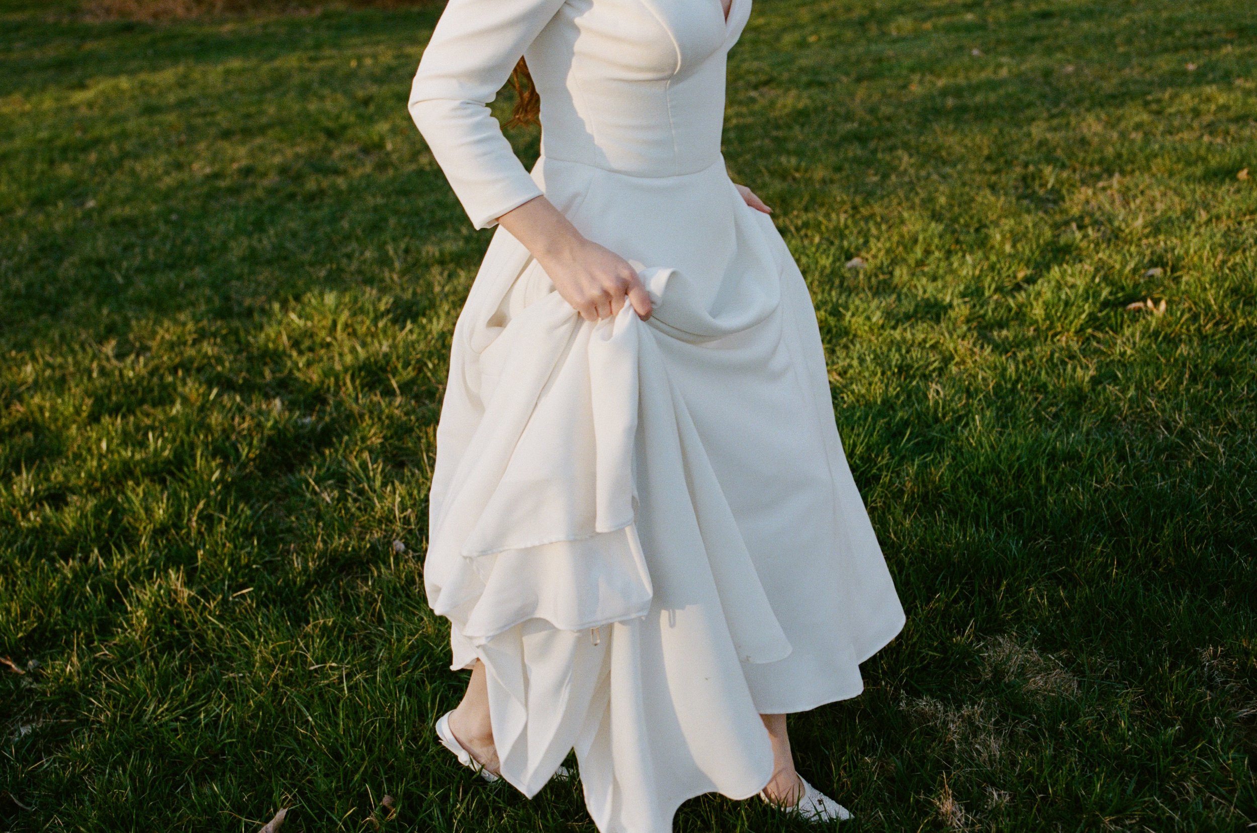 Bride frolicking in the grass in her wedding dress