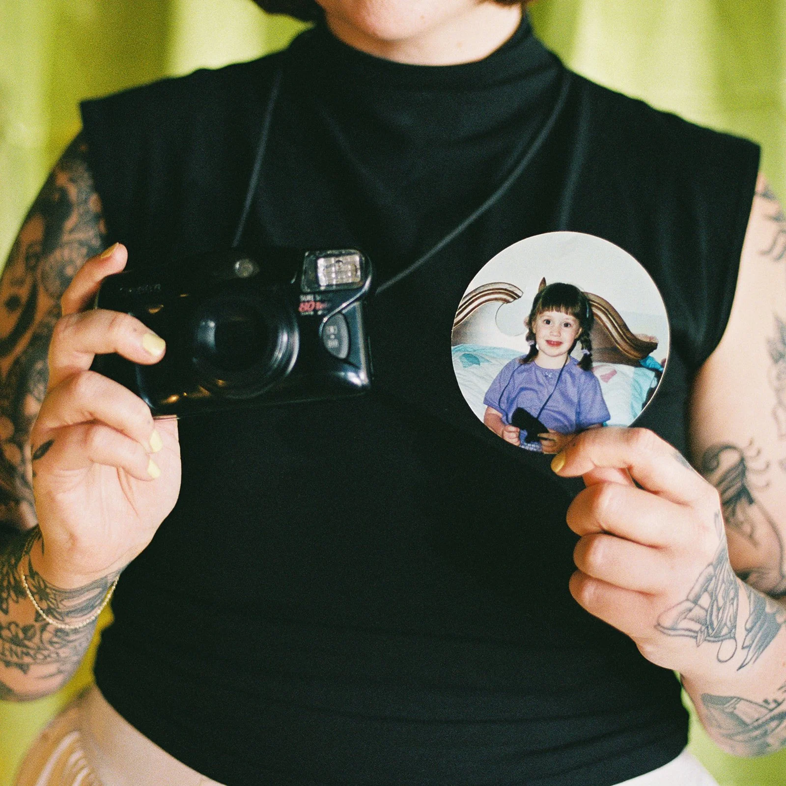 Rachel Crain holding a film camera and a photo of her as a little girl