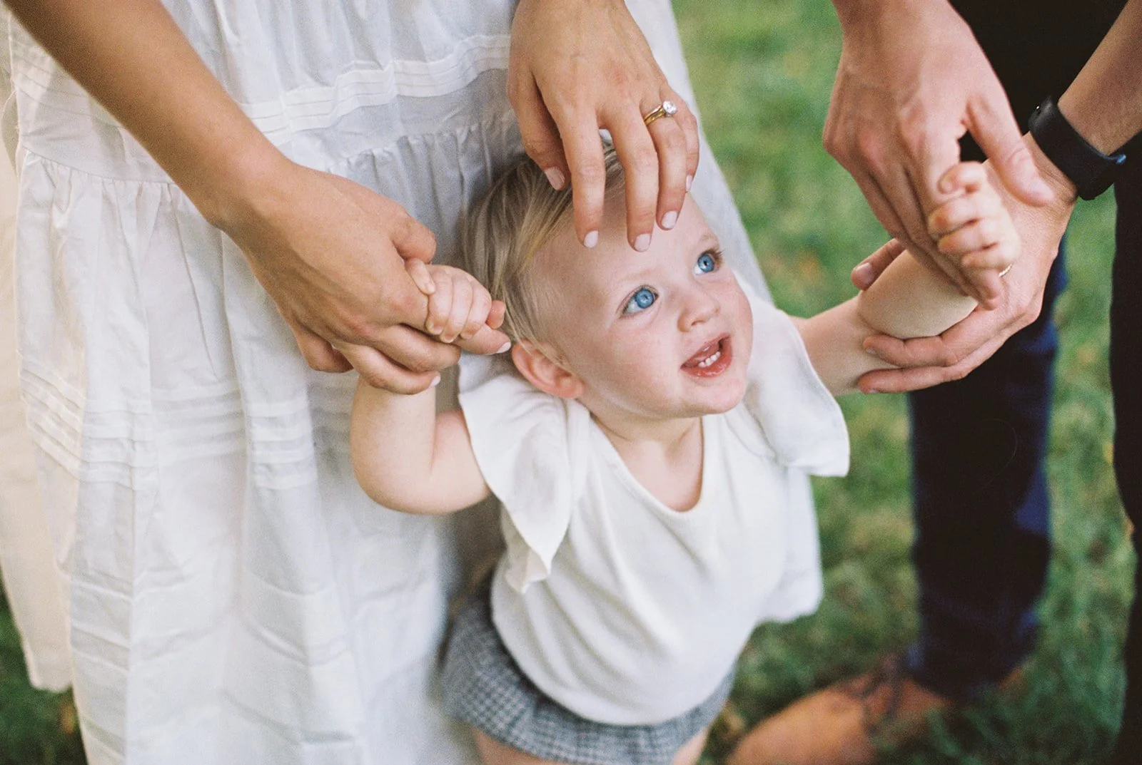 Young child looking up to their parents who are out of shot