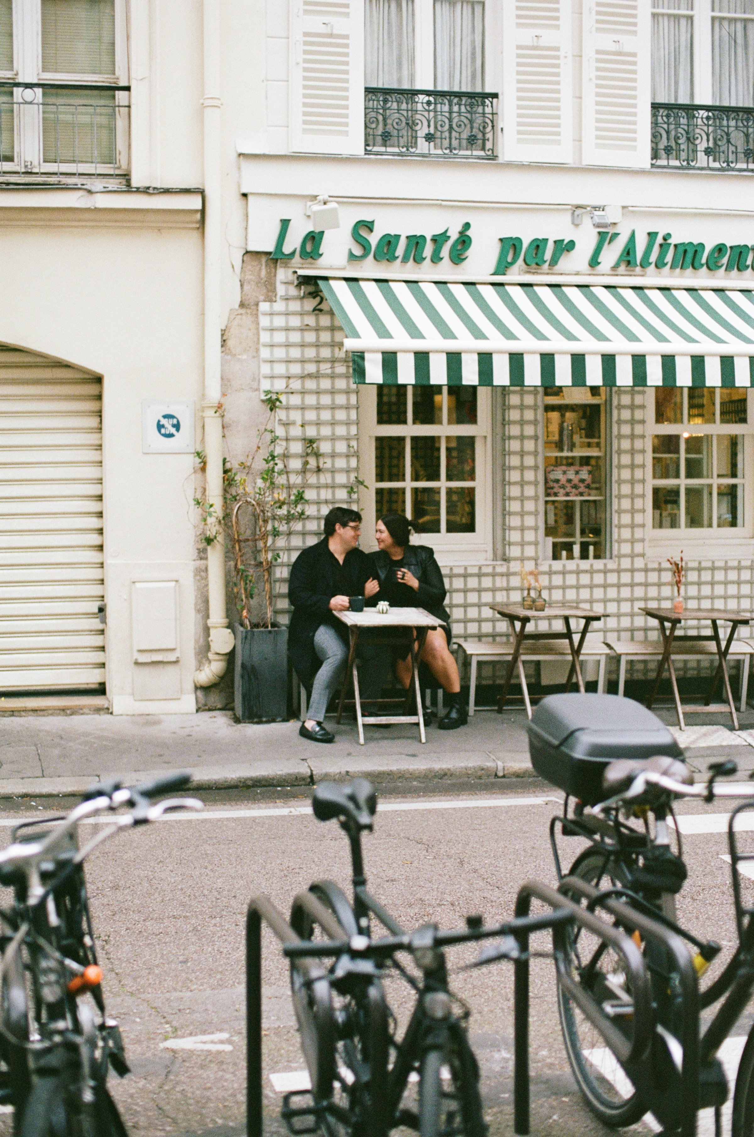Couple sitting at a sidewalk cafe, staring in each others eyes over the table