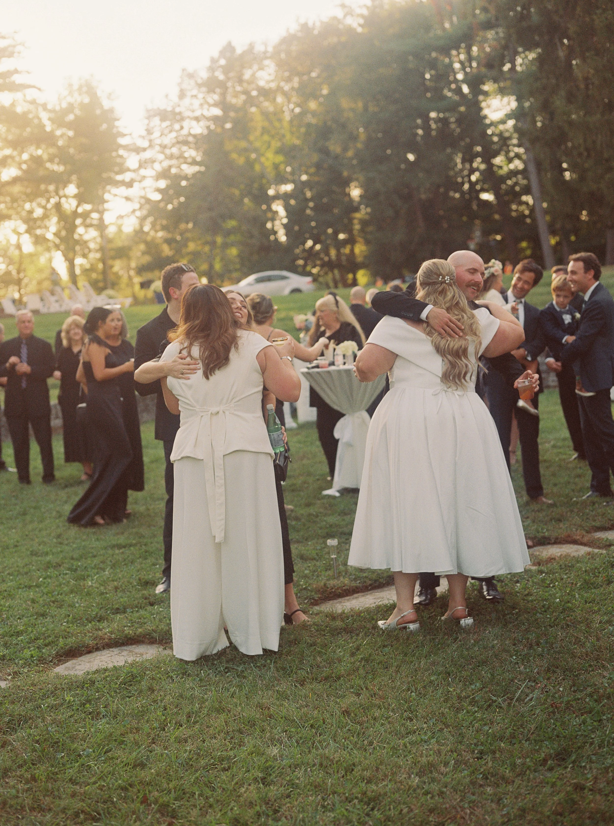 Wedding guests hugging and mingling at an outside wedding