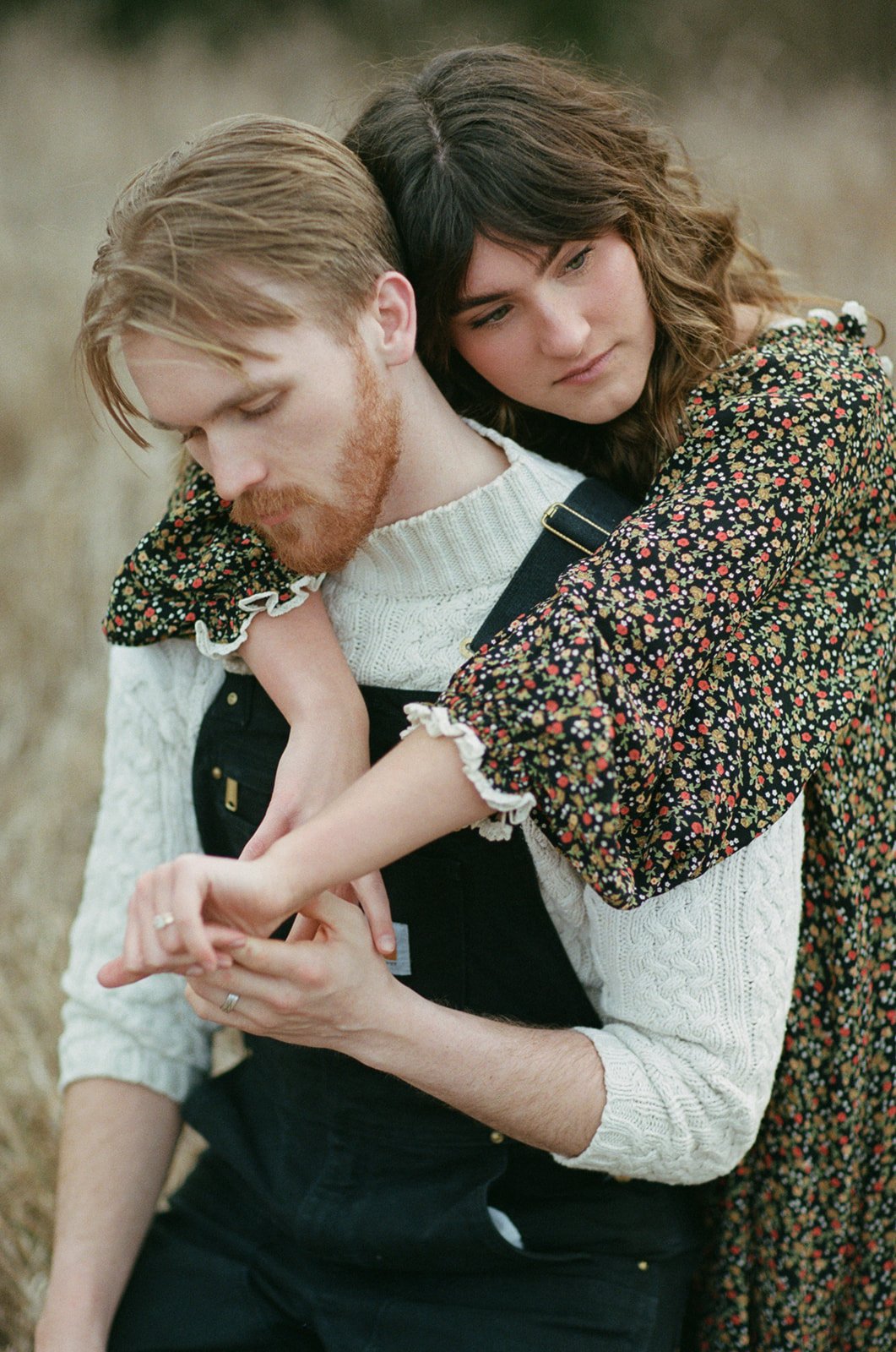 Intimate couple portrait of a couple with their arms around each other in a field