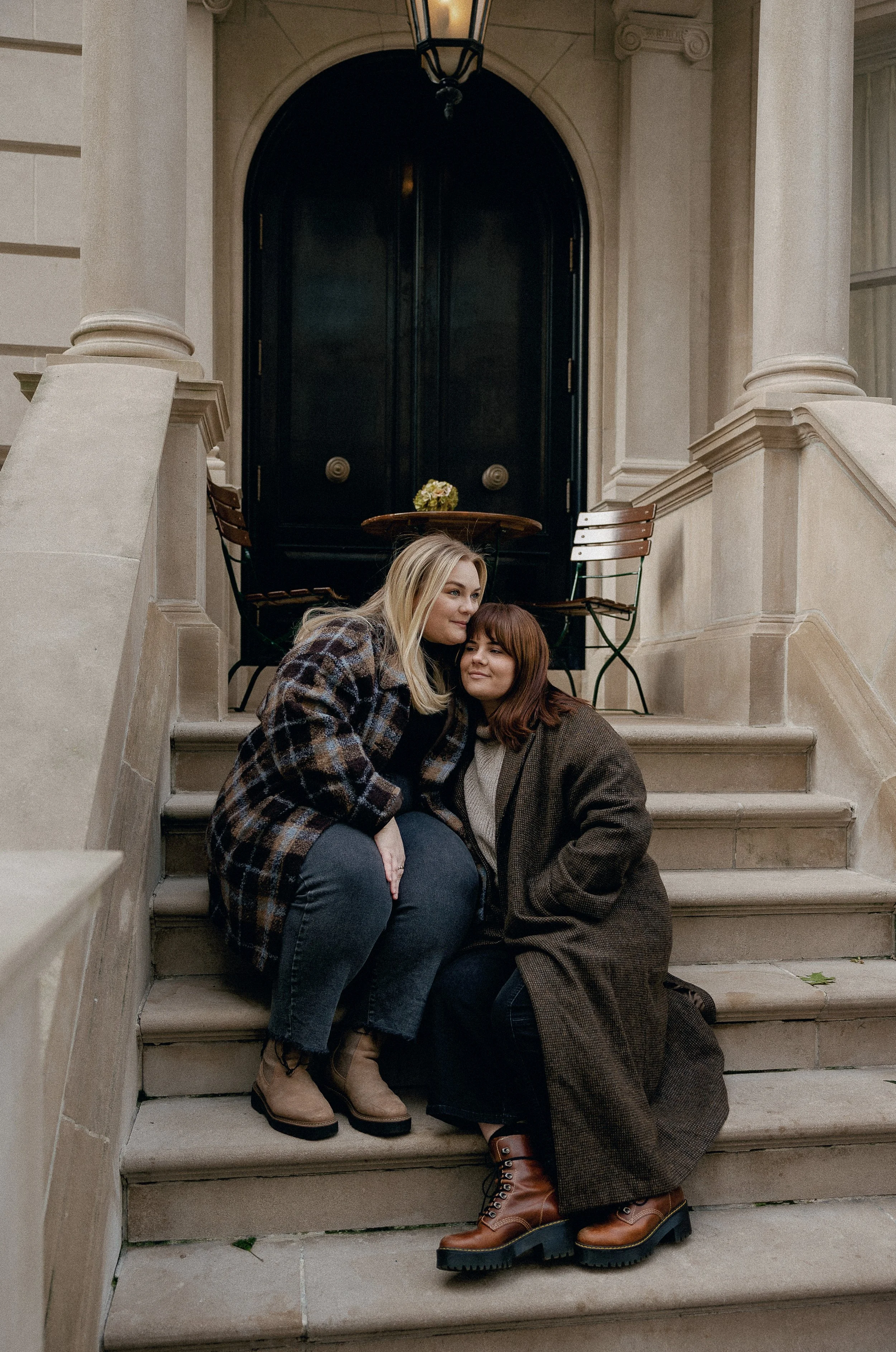 Couple on the steps of an old building, cozying up for the shot