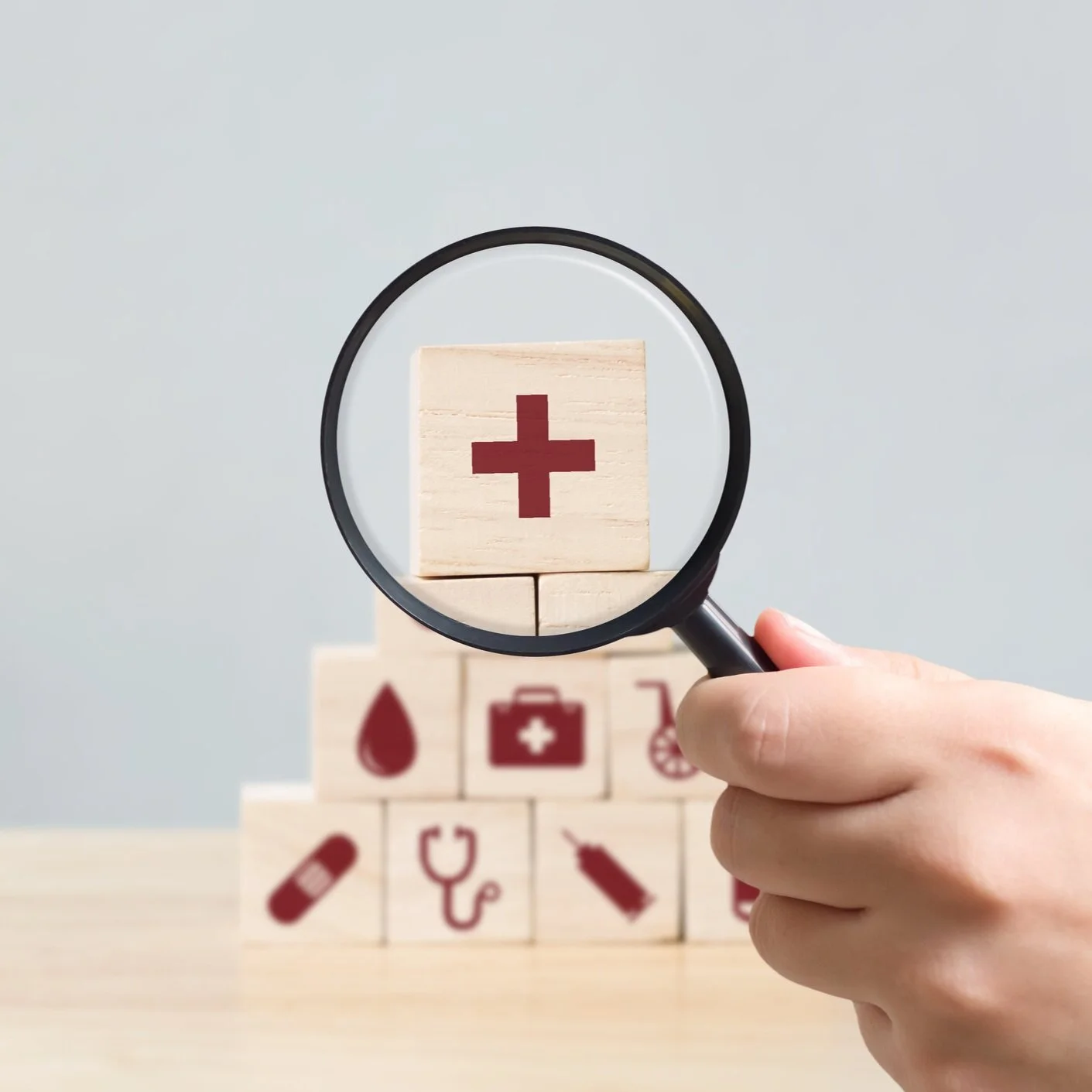 Canva+-+Hand+holding+magnifying+glass+to+wood+block+stacking+with+icon+healthcare+medical%2C+Insurance+for+your+health+concept.jpg