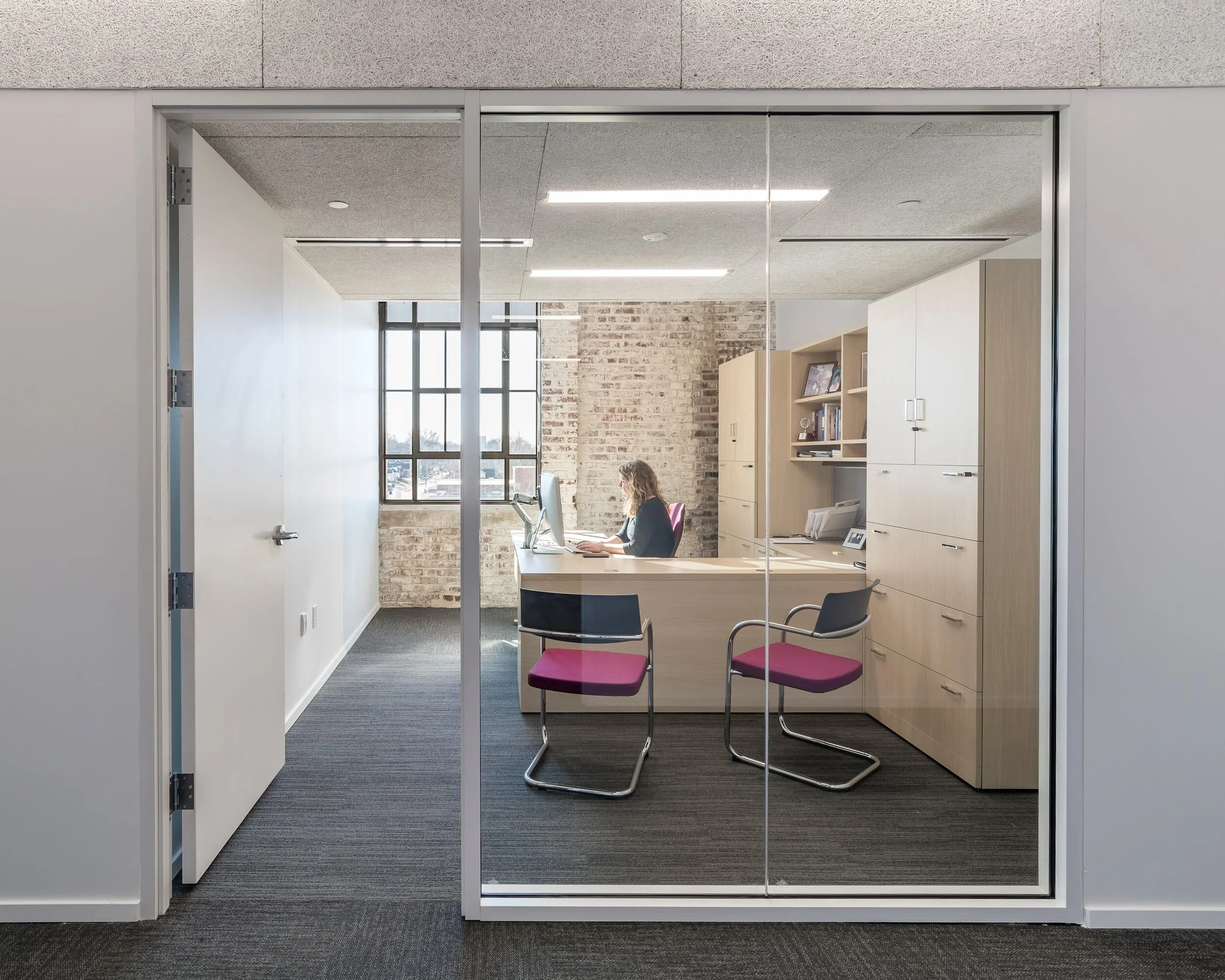 A private office is furnished with a desk, side chairs, and storage at Urban Child Institute