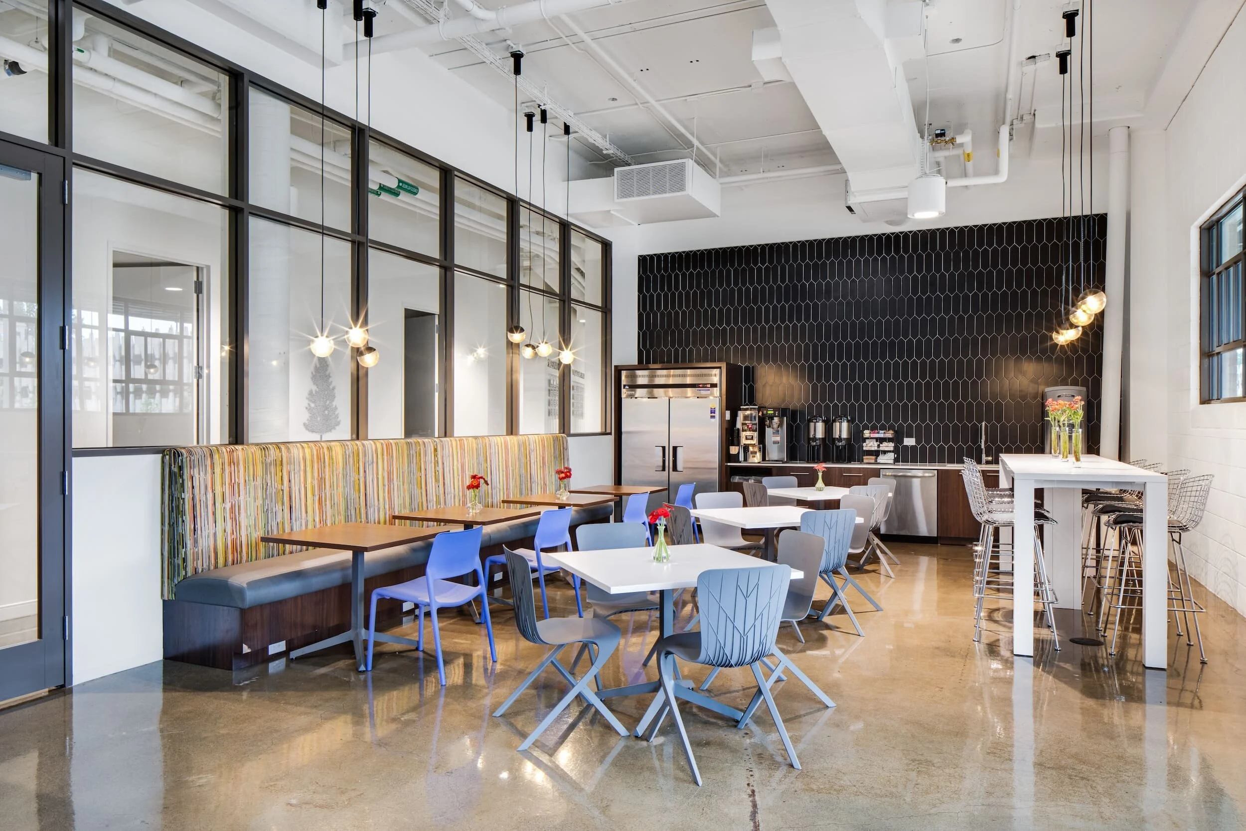 The break room in the nexAir corporate headquarters with dining chairs, dining tables, booths, high top tables and stools