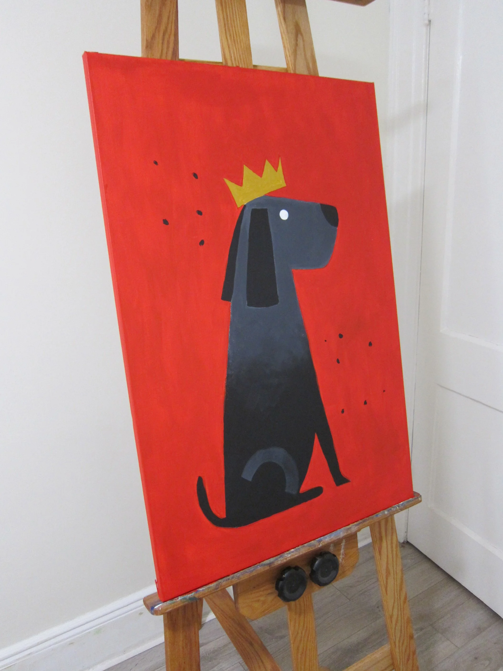 Black dog sitting with a crown on its head in an acrylic painting with a solid red background and simple shapes.