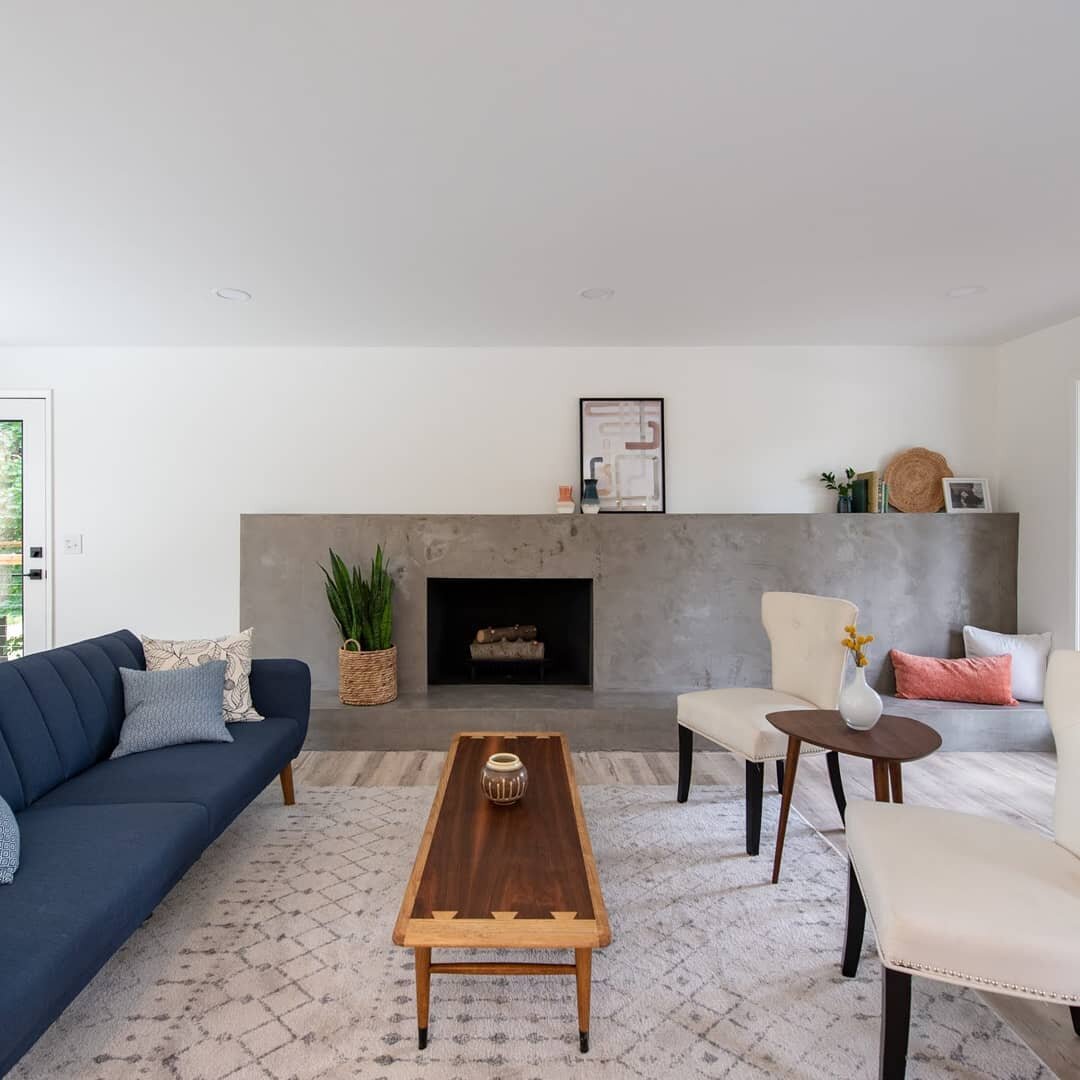 The fireplace is the main focal point for many living rooms, and therefore one of our favorites to make over! We gave this dated stone fireplace a modern facelift with this beautiful hand-applied concrete finish. The clean lines and surface texture r
