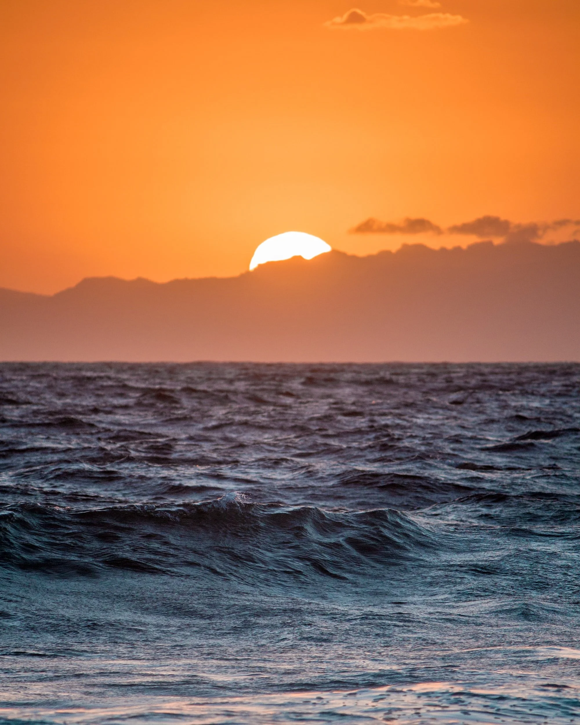 The sun sets behind clouds over the ocean horizon. Learn more about in-person therapy in Honolulu, HI and the support anxiety treatment in Honolulu, HI can offer. Therapy can offer support with mindfulness for anxiety and more.
