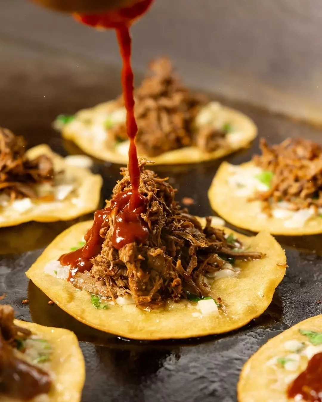 Our famous Birria Tacos with consomm&eacute; trace their origins to Tijuana, Mexico, where taqueros began filling corn tortillas with stewed birria, frying them to crispy perfection.
