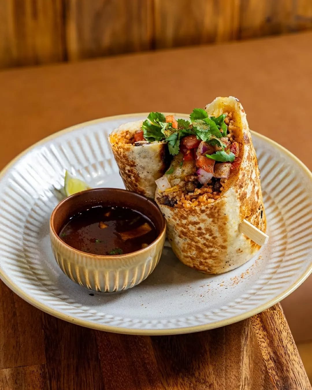 Meet El Burrito Bandido. Packed with your choice of protein, fries, jalape&ntilde;os, pico, Oaxaca cheese, guacamole and sour cream. Served with birria consomm&eacute; to dip.