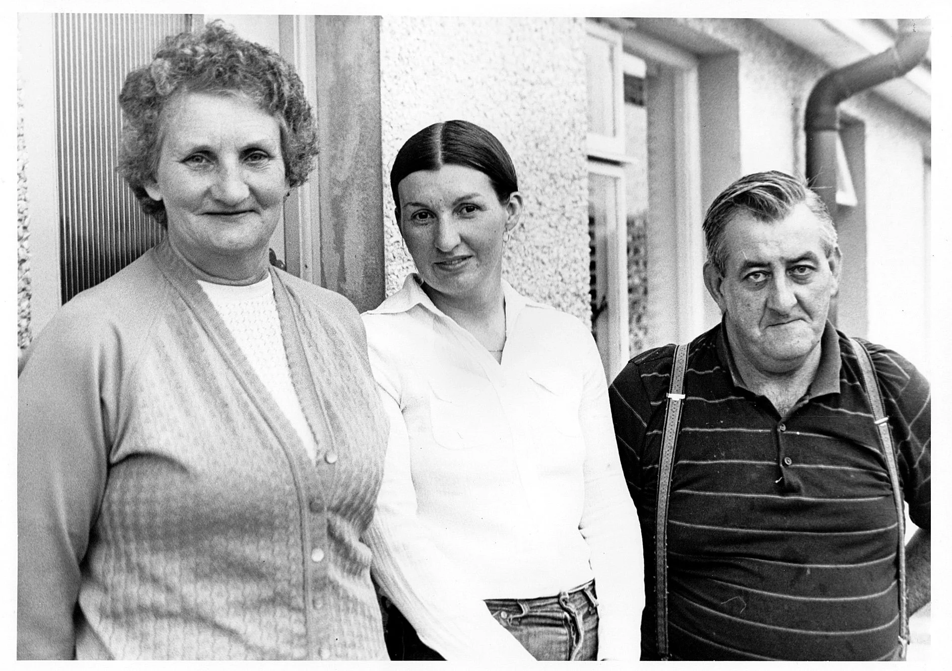 Three people posing together in an outdoor setting.