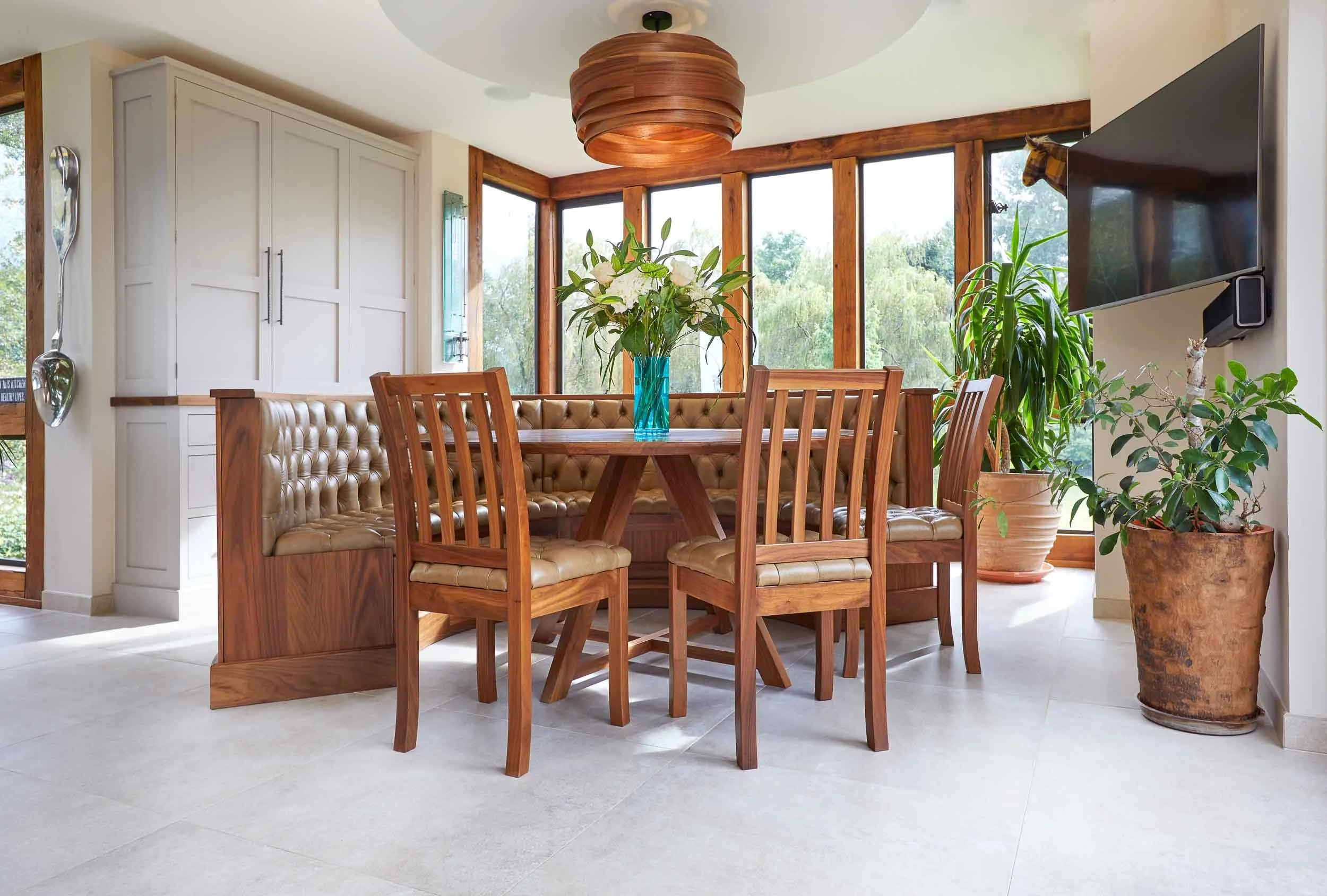 Semi circular freestanding walnut bench with leather upholstery, matching table and chairs