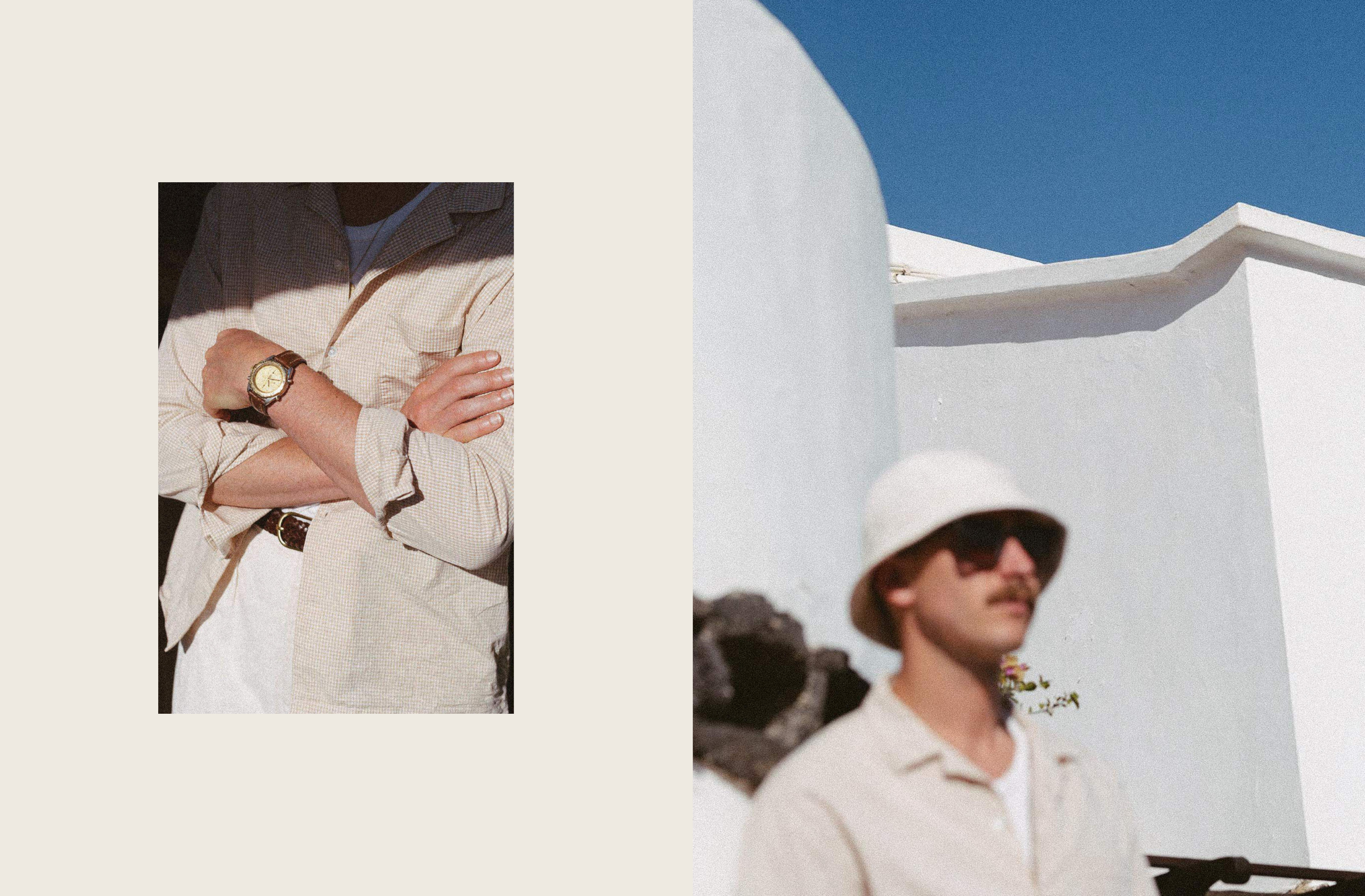 Homme portant un chapeau blanc, lunettes de soleil, moustache, vêtement clair, architecture blanche, ciel bleu.