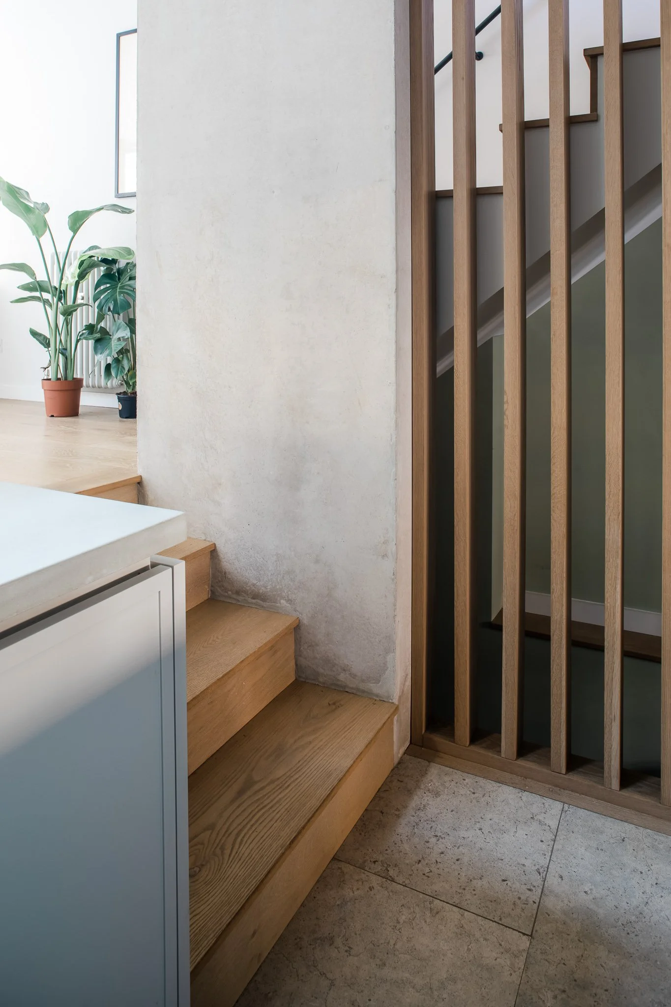 A refined stair detail where timber treads, vertical balustrades, and soft-toned plasterwork come together. Natural materials and subtle junctions create a calm transition between levels, celebrating craftsmanship and simplicity.