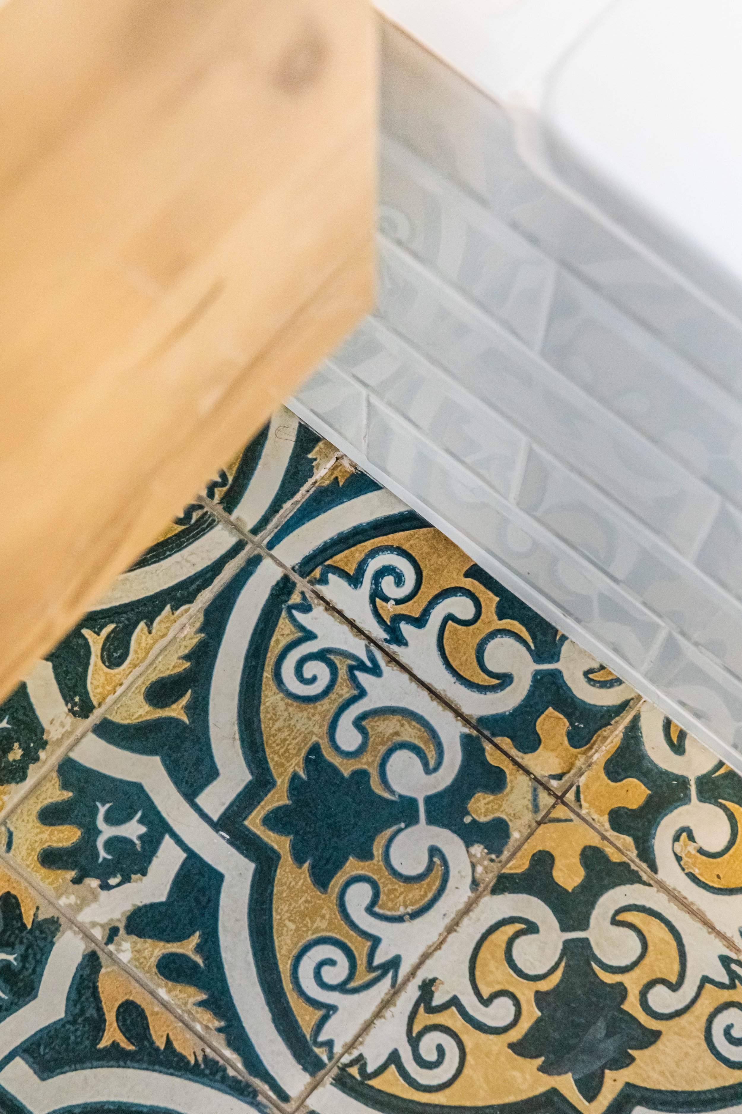 Blue white and yellow mediterranean floor tile with white metro tile and wooden vanity Orsetto Interiors London UK.jpg