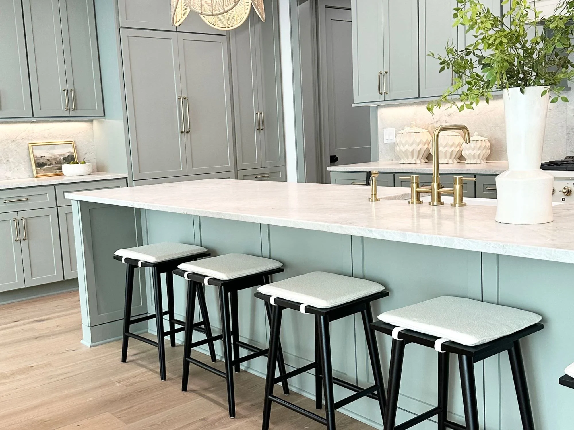 base of greenery on island and bar stools