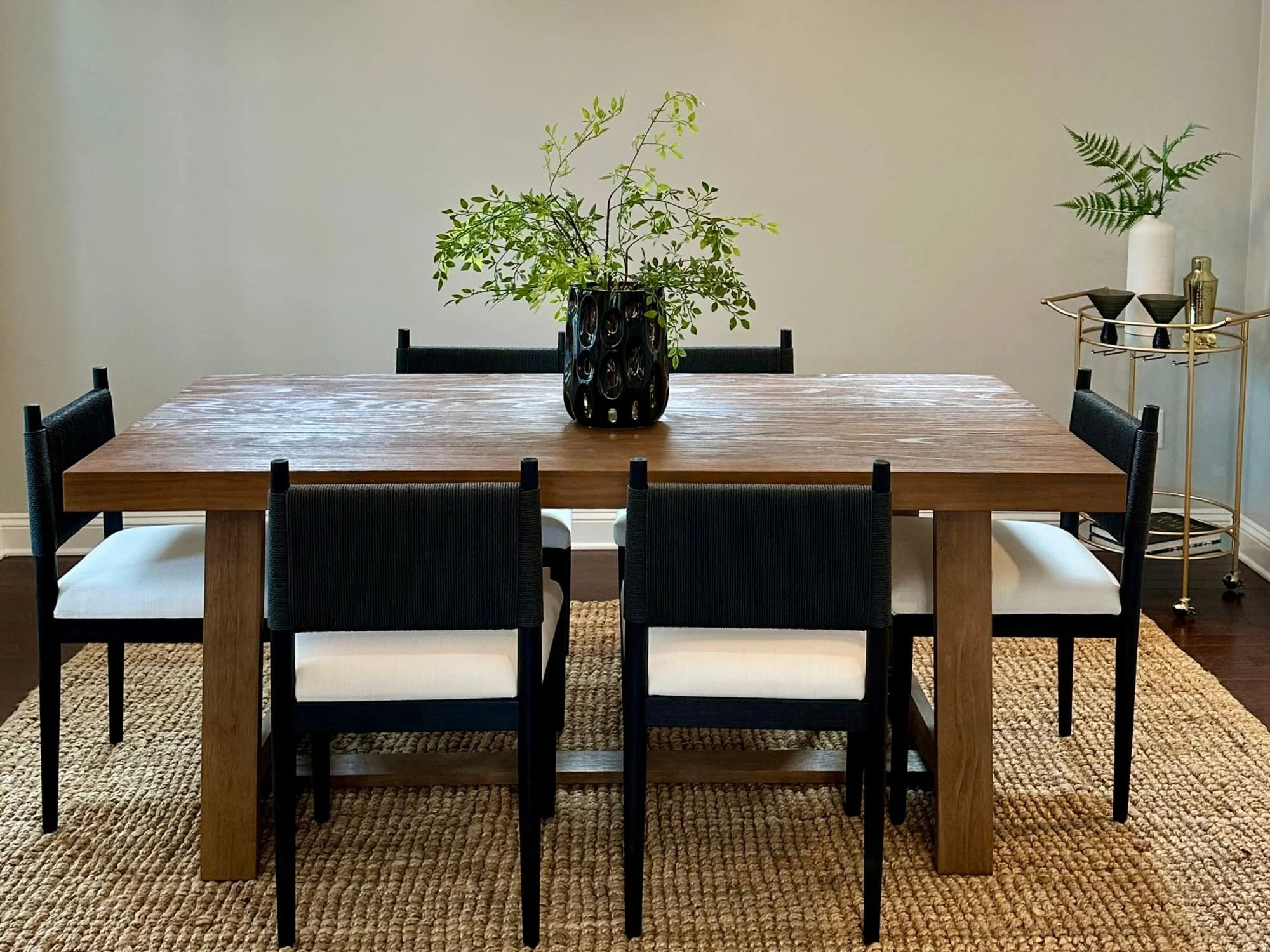 wooden dining table with bar cart in corner