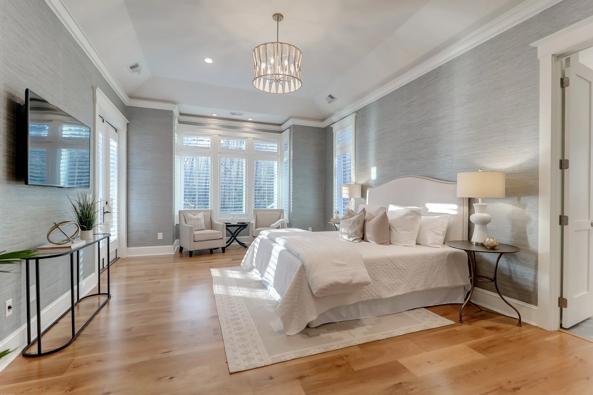 beautiful bedroom with table, nightstands and 2 sitting chairs