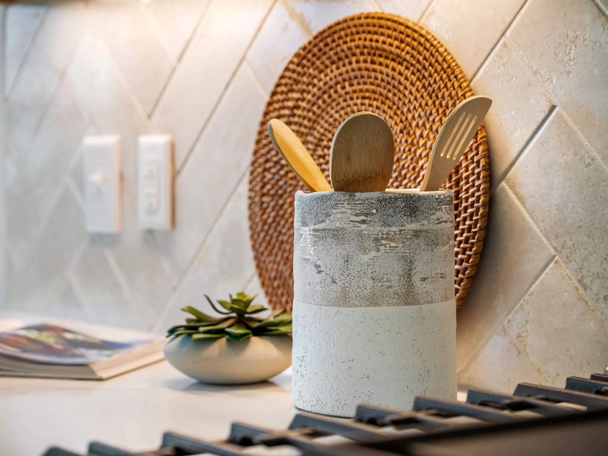 cookbook, utensils and plant on kitchen counter