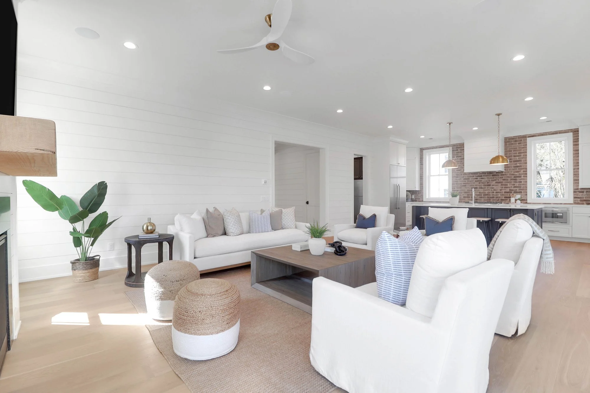 white couches, white side seats, coffee table in large open floor plan