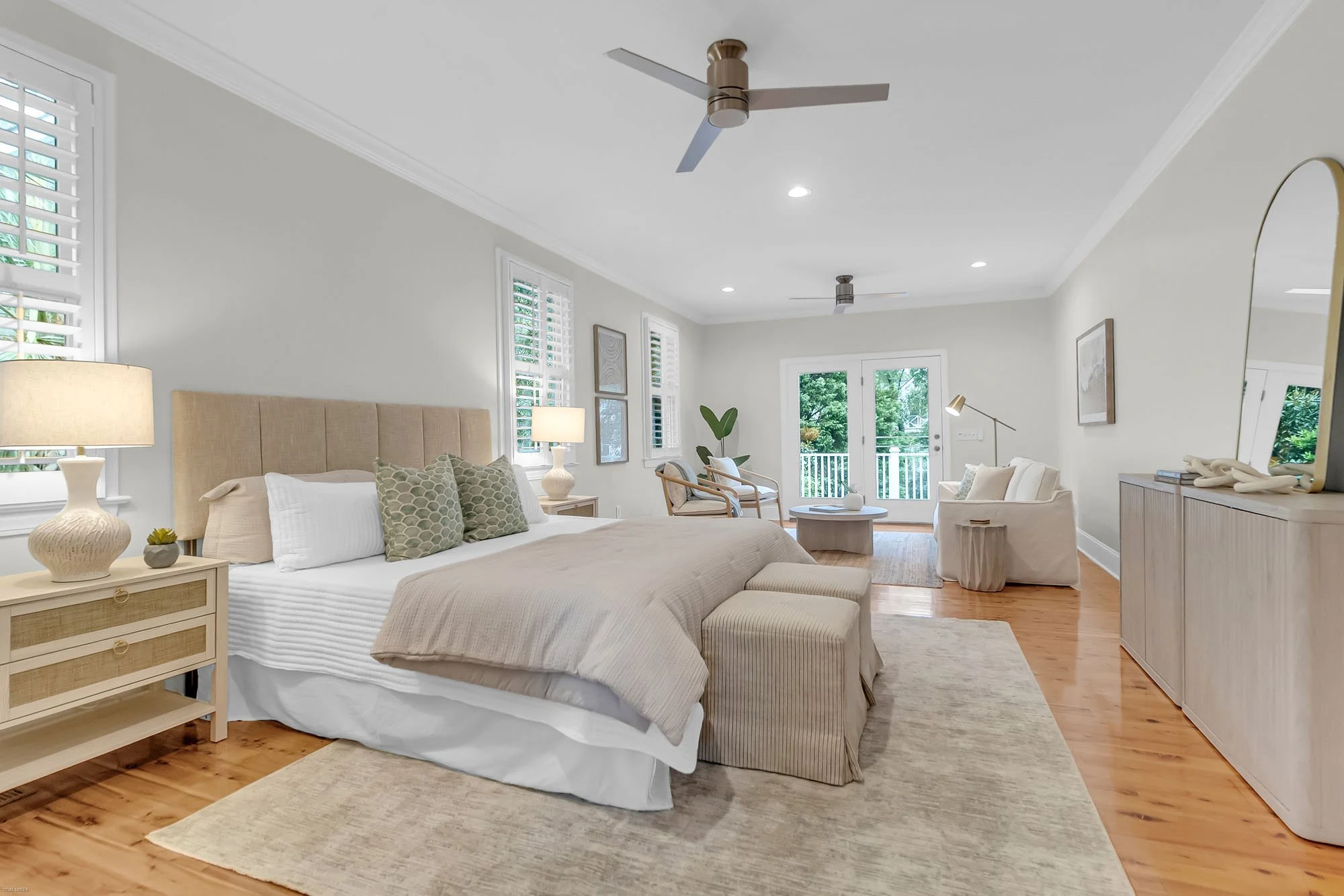 bed, dresser and nightstand and sitting area in primary bedroom - real estate home staging