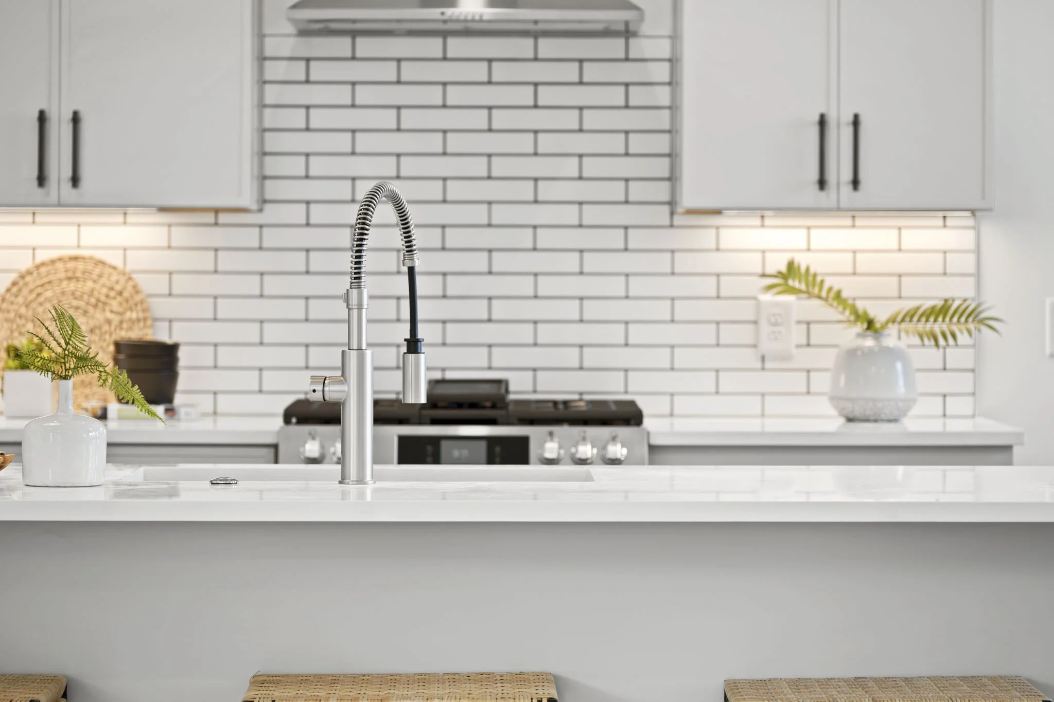 kitchen with greenery and white and black backsplash - home staging cost