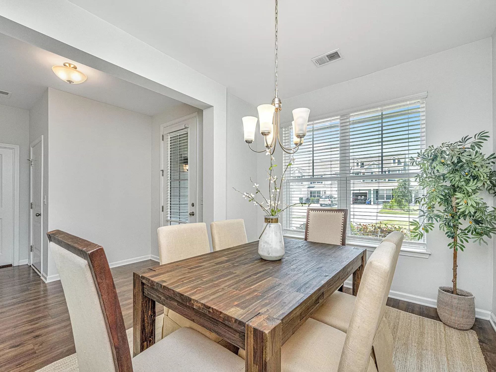 wooden table with matching chairs and greenery on top