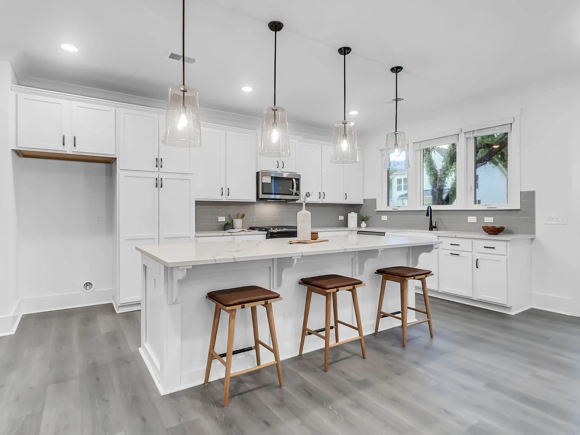 beautiful white kitchen and island with brown bar stools