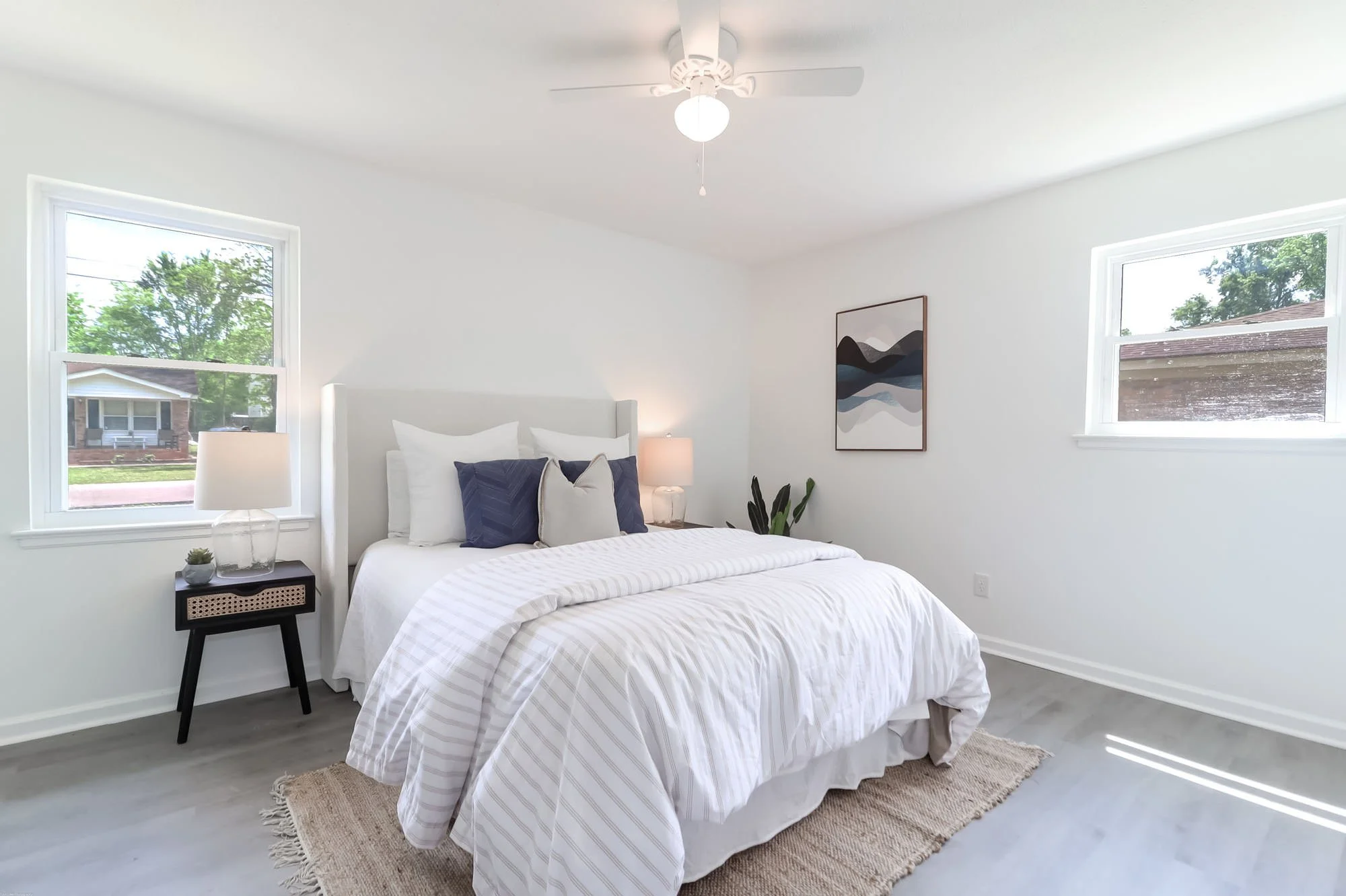 beautiful bedding, artwork, and nightstand