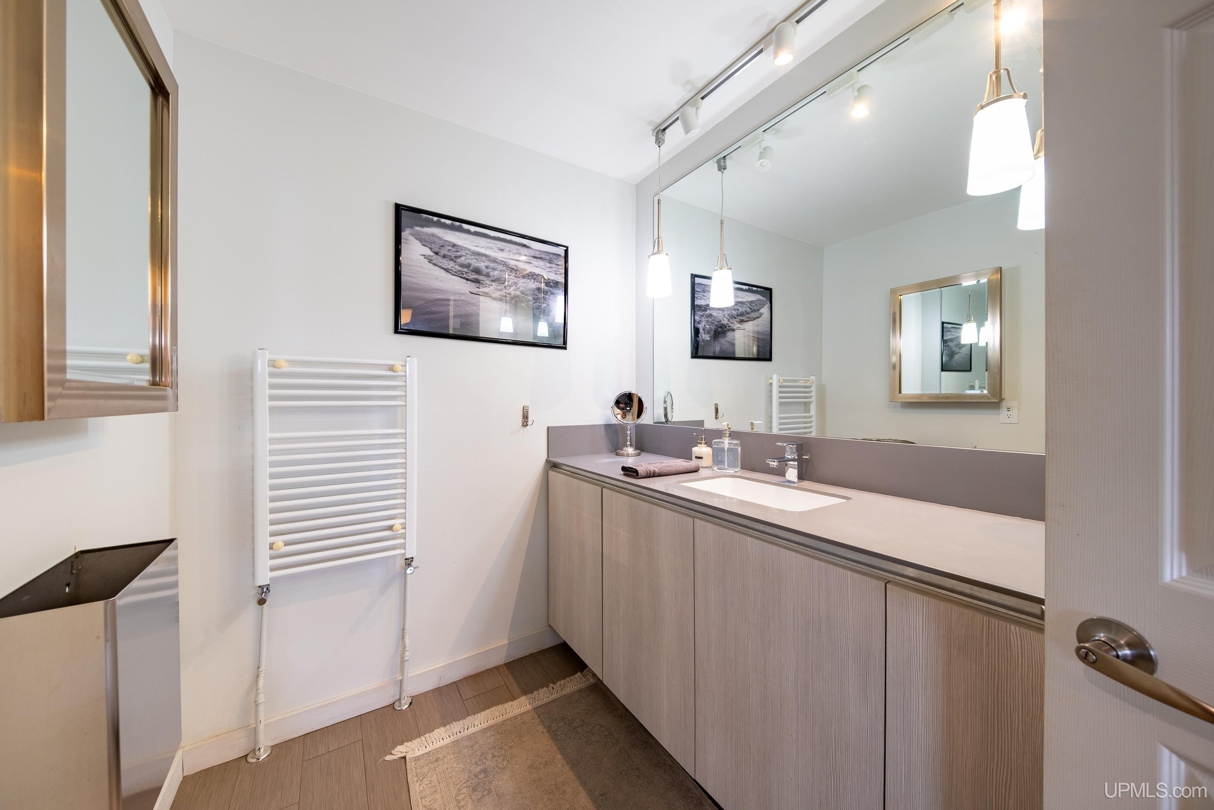 A single sink vanity with mirror inside a bathroom.