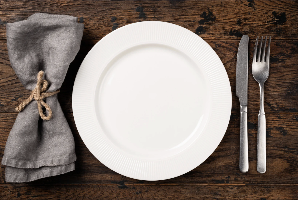 table setting with white plate on dark wooden table