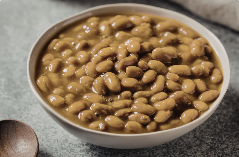cooked beans in a white bowl on kitchen counter